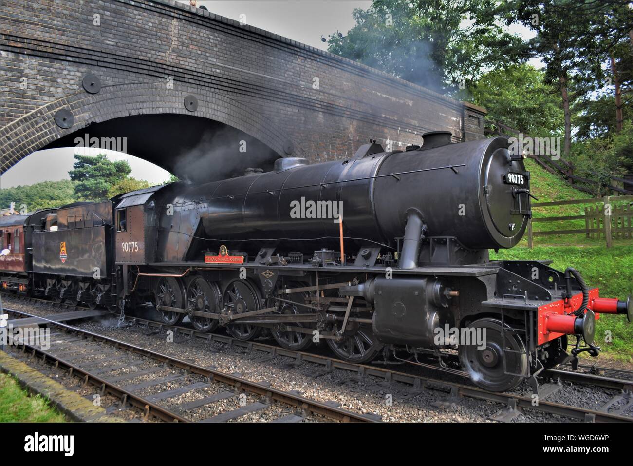 Royal Norfolk regiment Dampflok auf der North Norfolk Bahn durch die Brücke bei weyborne Station. Stockfoto