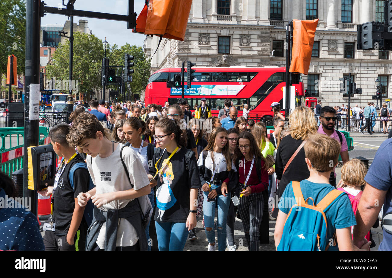 Überfüllte Straßenbeläge und Menschenmassen, die in der City of Westminster, City of London, Großbritannien, über Fußgängerübergänge laufen. Hektik. London beschäftigt. Stockfoto