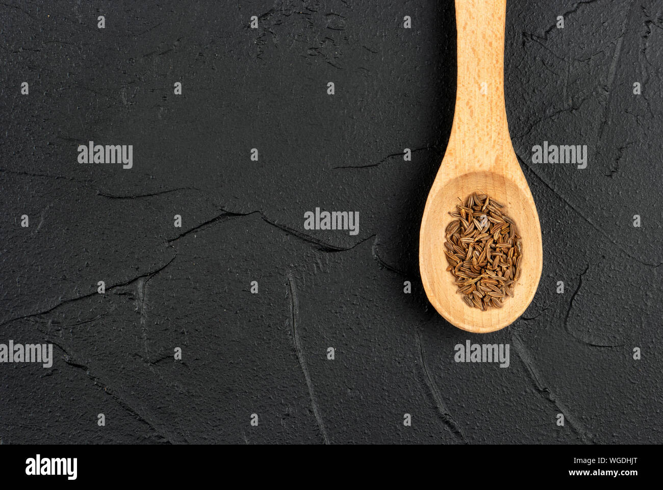 Kleine Löffel mit trockenen Kreuzkümmel close-up auf konkreten Hintergrund Stockfoto
