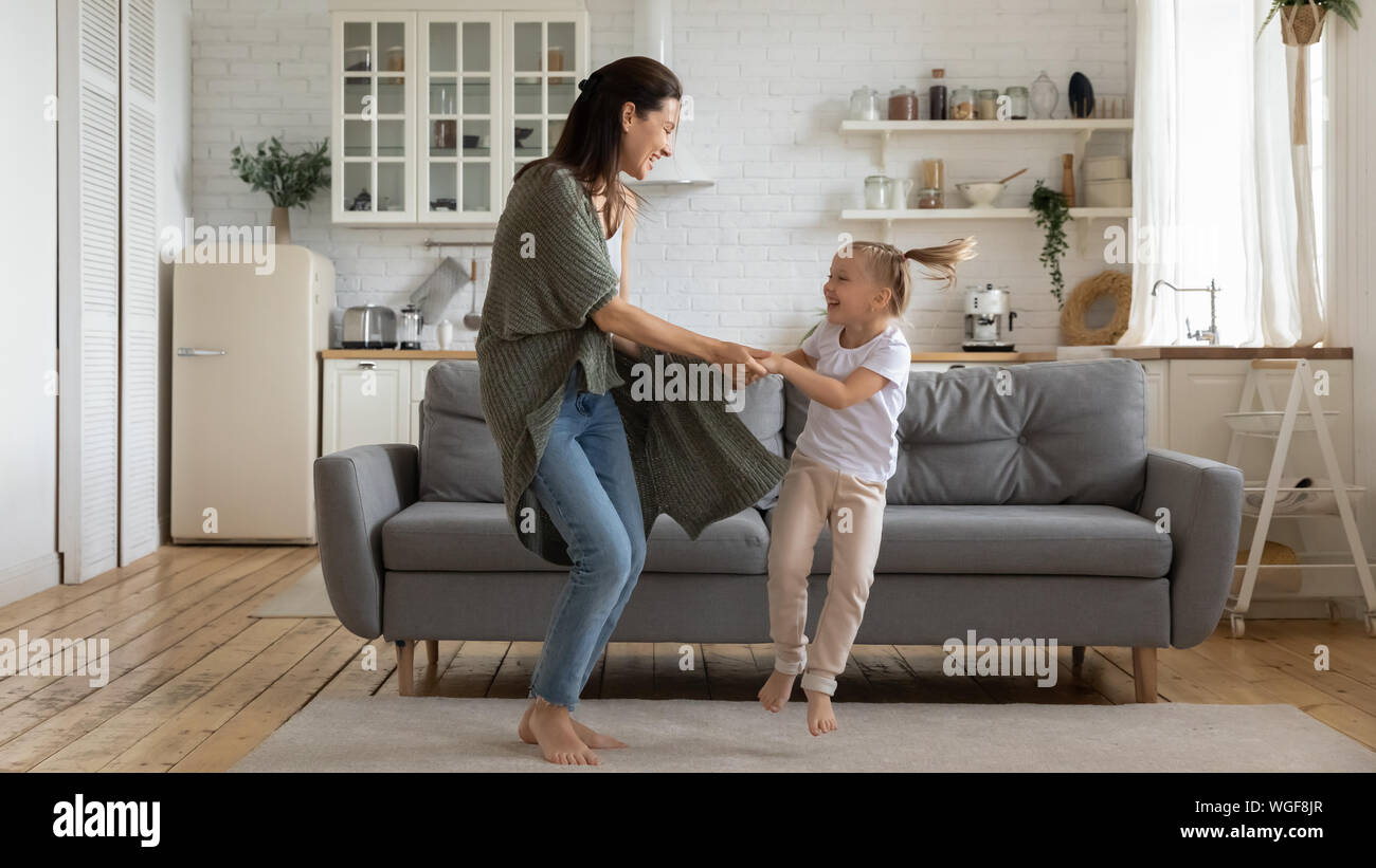 Mutter tanzen Hände mit Tochter im Vorschulalter zu Hause Stockfoto