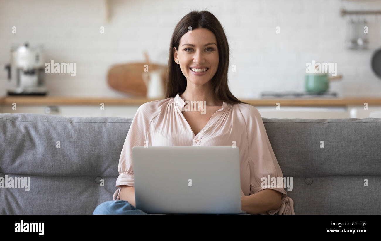 Frau sitzt auf der Couch halten Computer Kamera suchen Stockfoto