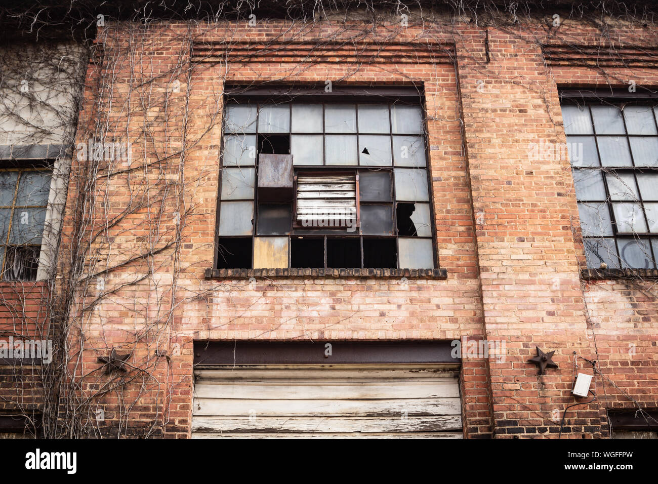 Kaputte Fenster und Kletterpflanzen hinzufügen, um die traurigen Elend dieser verlassenen Gebäude in der Innenstadt von Asheville, NC, USA. Stockfoto