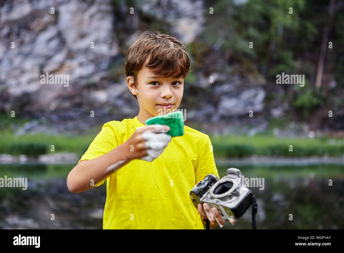 Ein kleiner Junge hat eine Nassreinigung der CMOS-Sensor, der sich auf digitale Kamera seines Vaters. Ein ungezogenes Kind Tücher ein SLR-Sensor der digitalen Kamera über einen Stockfoto
