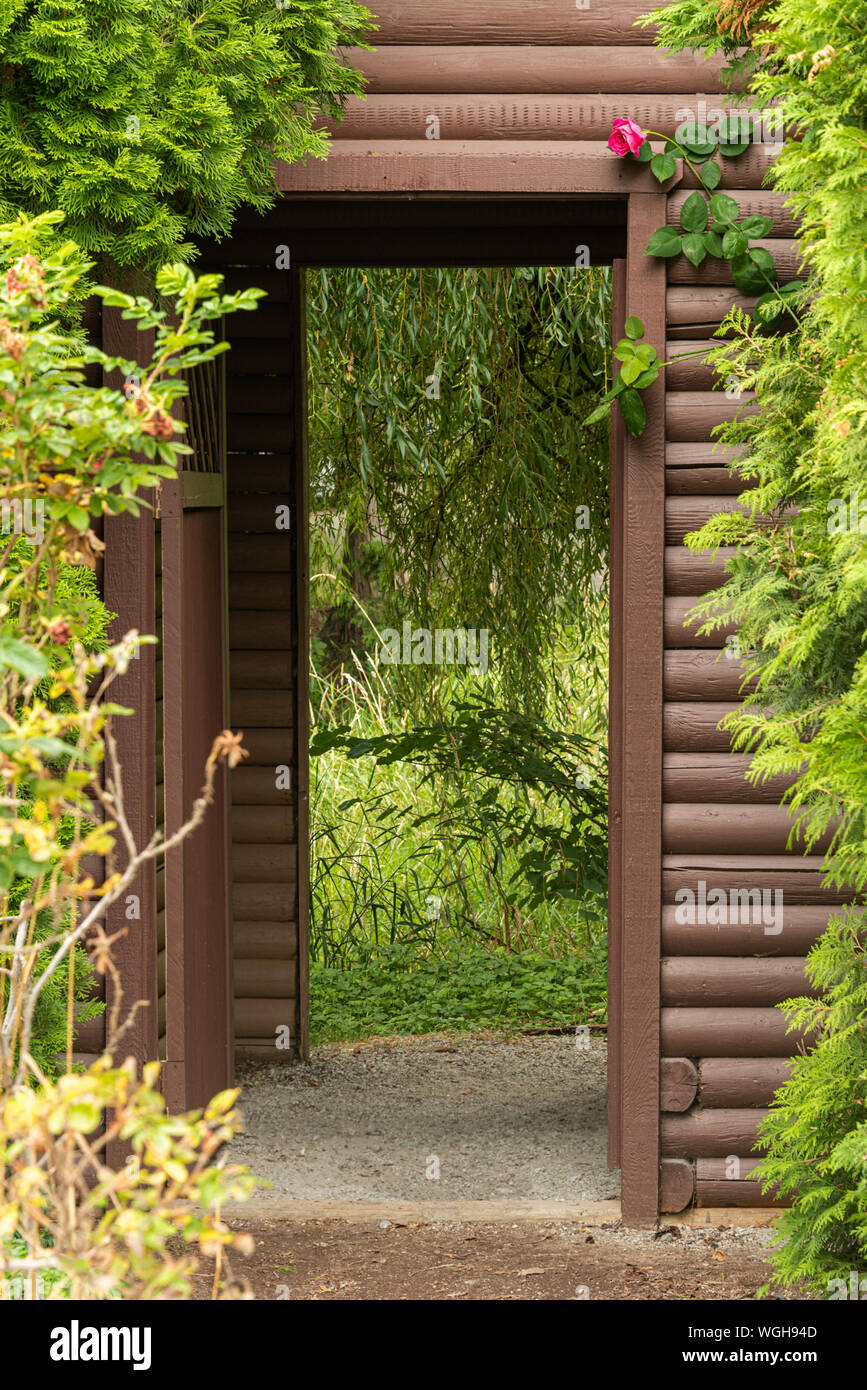 Anmelden gestaltete Tor mit roten Rose über dem Eingang. Stockfoto