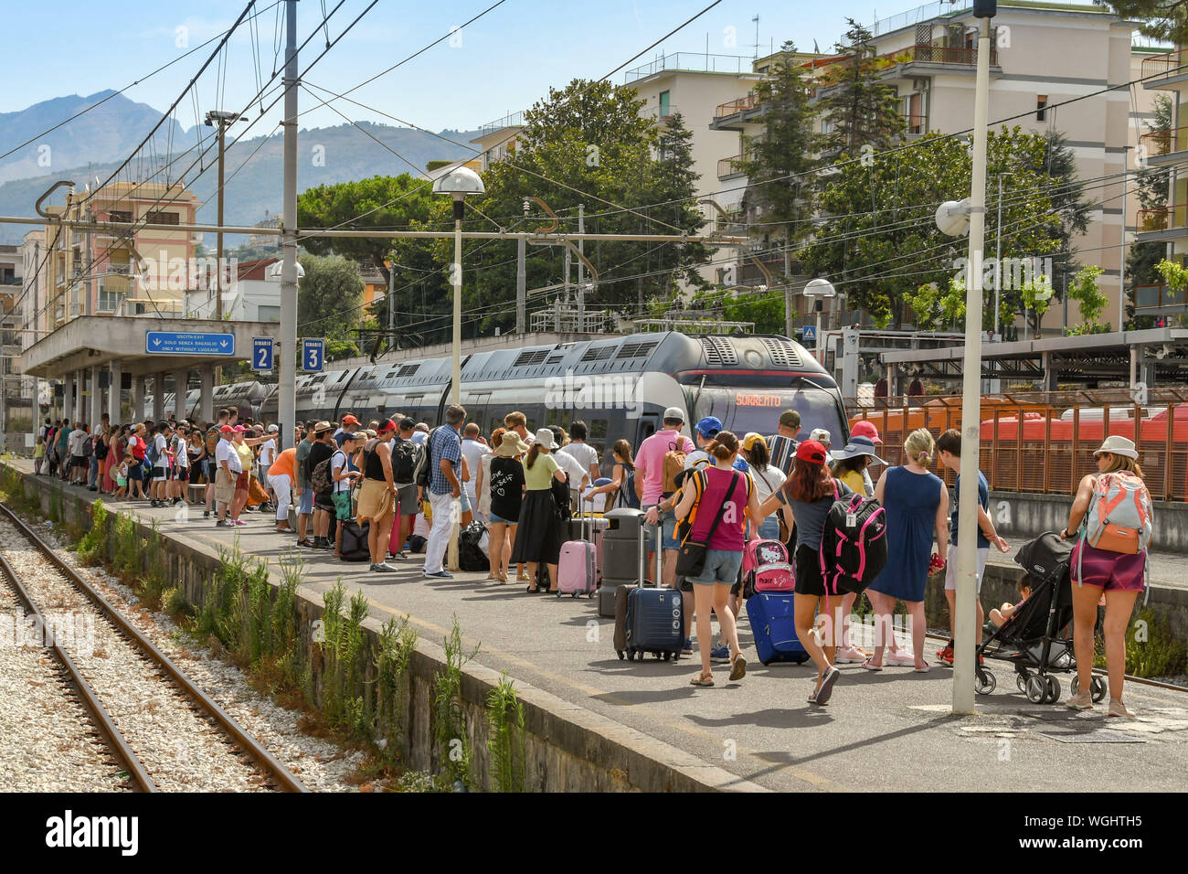 SORRENTO, ITALIEN - AUGUST 2019: Masse der Leute auf einer Plattform als am Bahnhof Sorrento Bahnhof ankommt. Stockfoto
