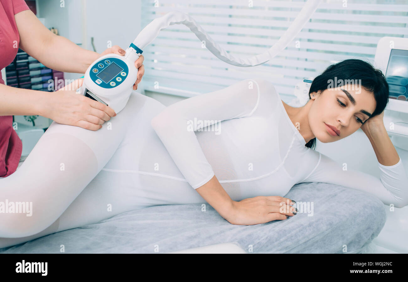 Frau erhalten Anti Cellulite Massage mit speziellen Ausrüstungen für die Schönheitspflege. Überschüssiges Fett auf den Hüften zu entfernen. Schlanke Körper nach lpg-Massage Stockfoto