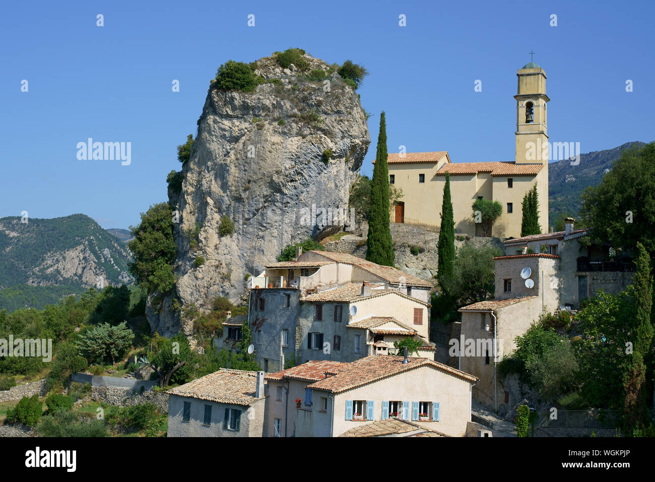 LUFTAUFNAHME von einem 6-Meter-Mast. Kalksteinmonolith, geneigt zu einer Kirche. Pierrefeu, Estéron Valley, Alpes-Maritimes, Frankreich. Stockfoto