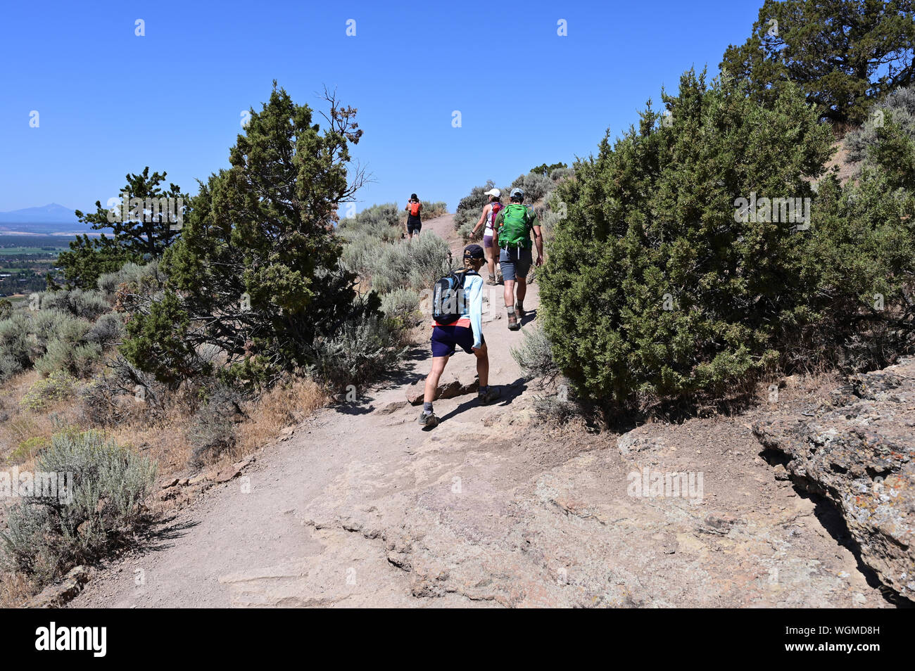 Wanderer auf Elend Ridge Trail in Smith Rock State Park in der Nähe von Terrebonne, Oregon an einem wolkenlosen Sommertag. Stockfoto