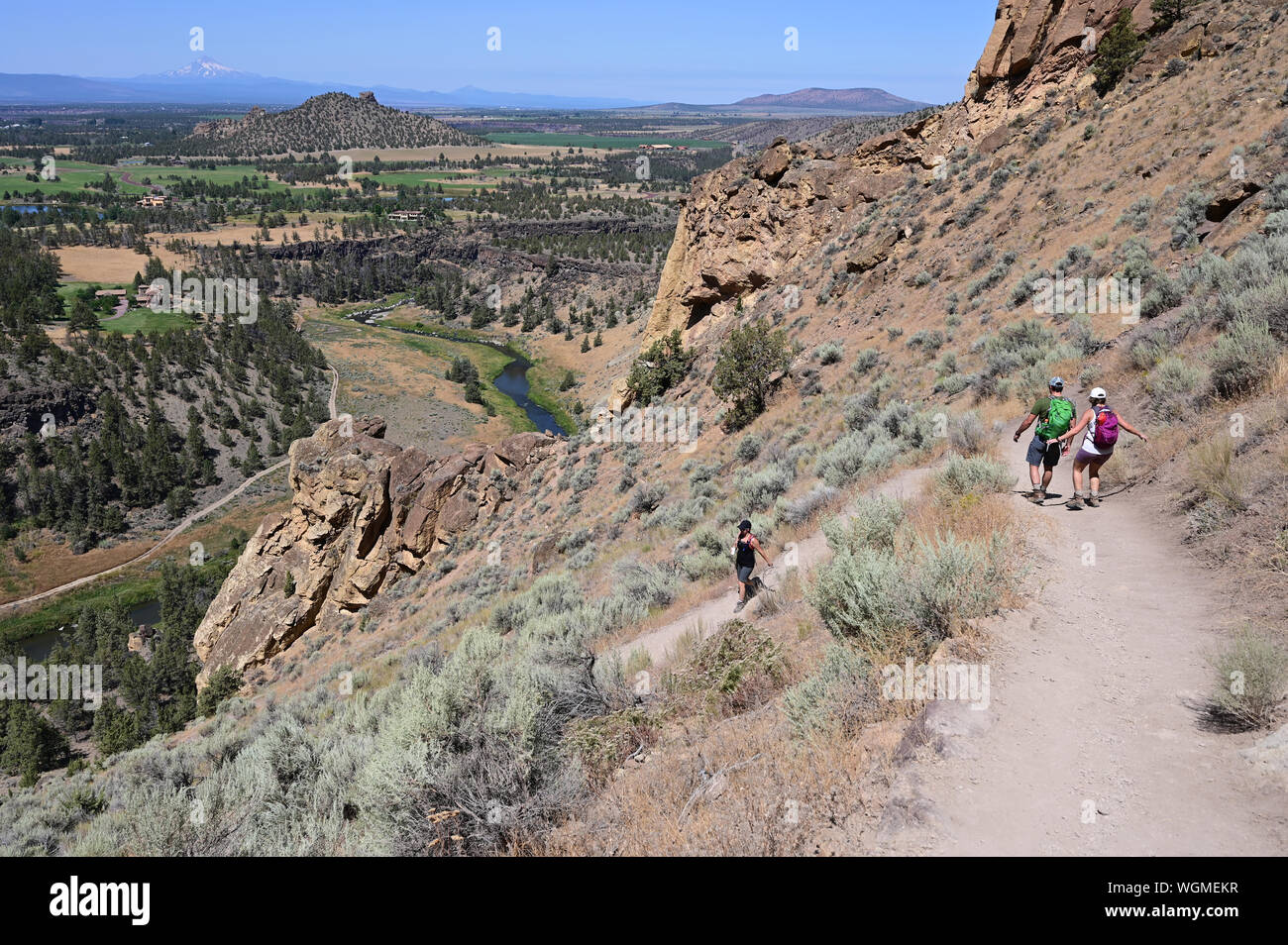 Wanderer auf Elend Ridge Trail in Smith Rock State Park in der Nähe von Terrebonne, Oregon an einem wolkenlosen Sommertag. Stockfoto