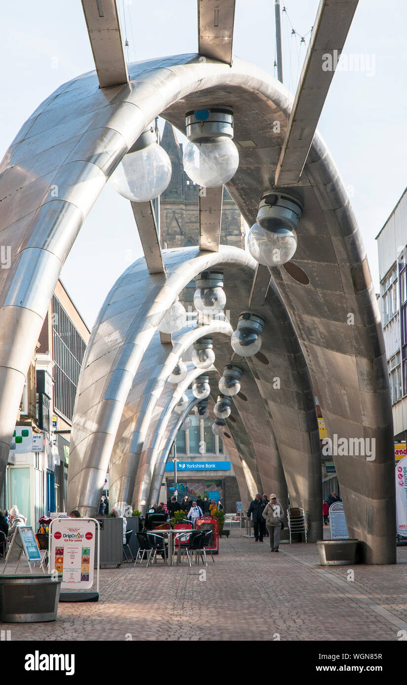 Menschen zu Fuß die Straße runter unter modernen futuristische Edelstahl Projektion Beleuchtung Bögen in Blackpool, Lancashire, England, Großbritannien Stockfoto