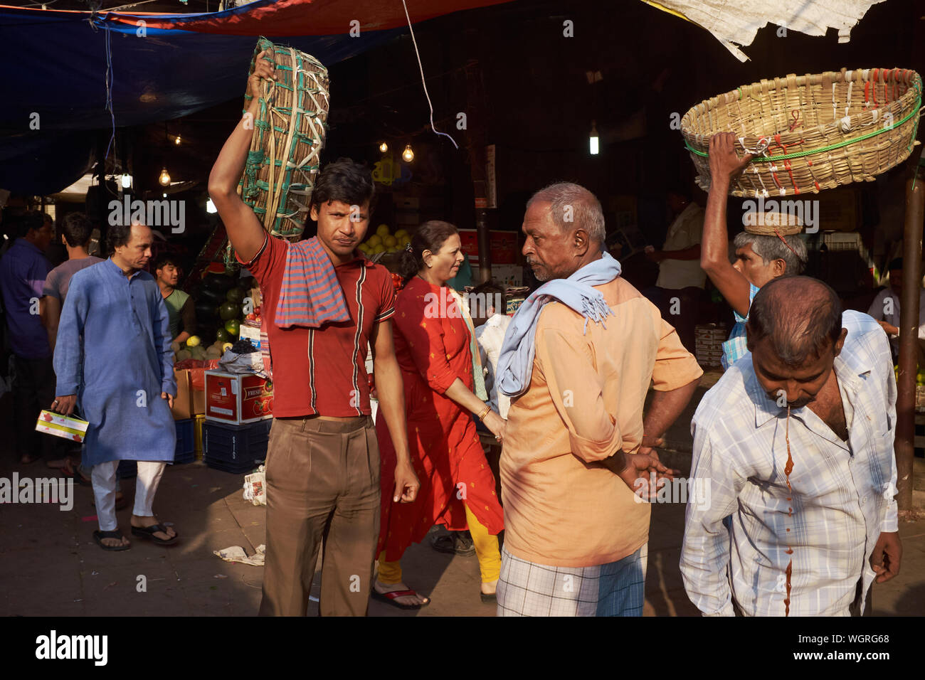 Träger mit ihren Körben bei Crawford Market (Mahatma Jyotiba Phule Market) in Mumbai, Indien, ein Kollege (r) spuckt Rot betel Saft Stockfoto