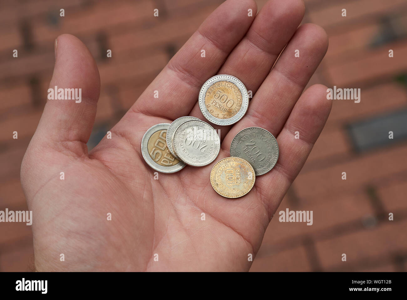 Kolumbianischer Peso Münzen in der Hand gehalten Stockfoto