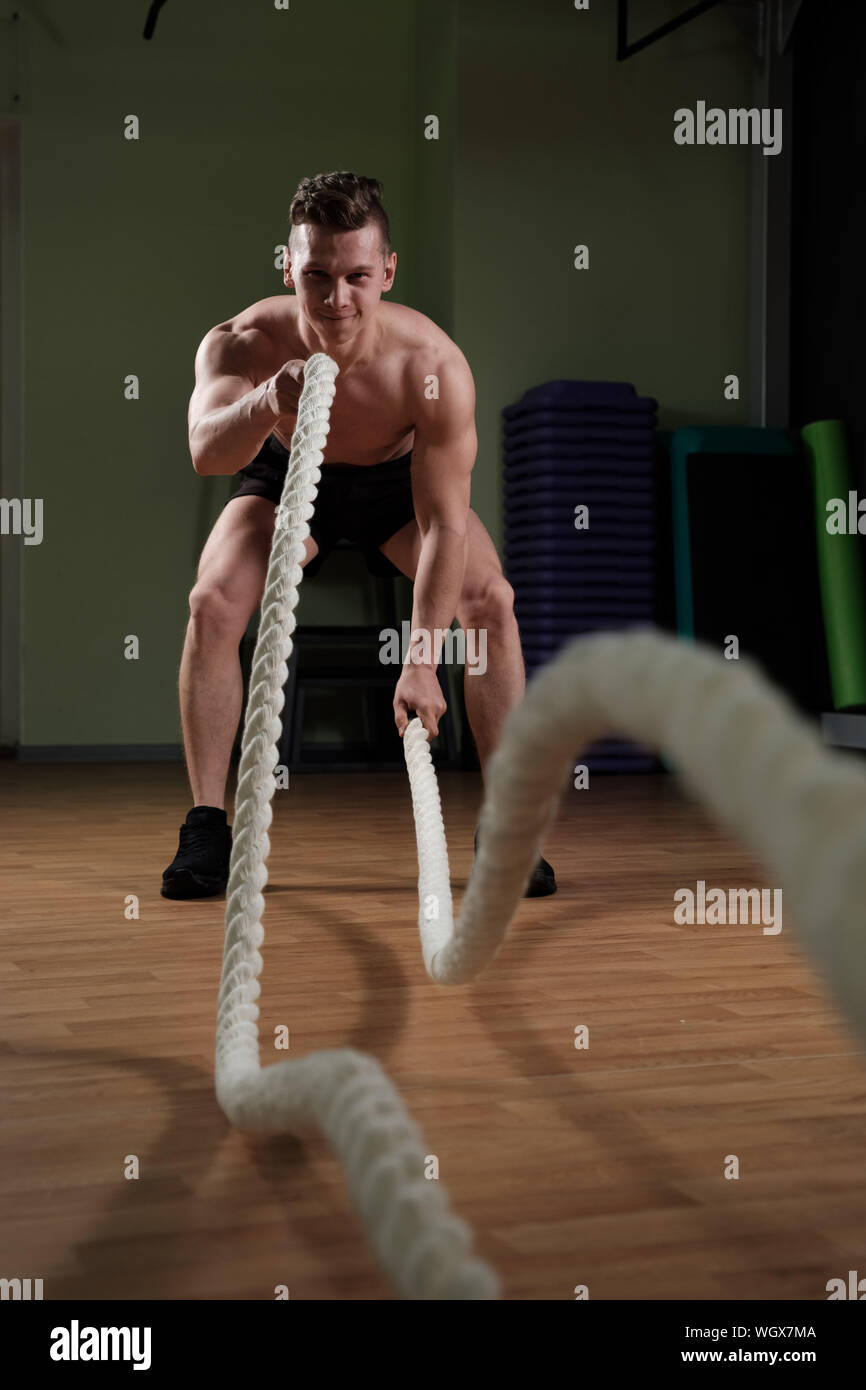 Sportler arbeiten mit Schlacht Seil im Fitnessstudio Stockfoto