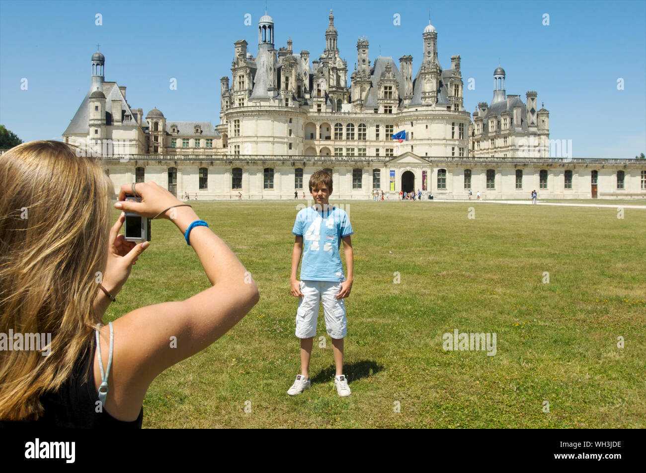 Mädchen, das ein Foto eines Jungen vor Schloss Chambord, Blois im Loire-tal, Frankreich posing Stockfoto