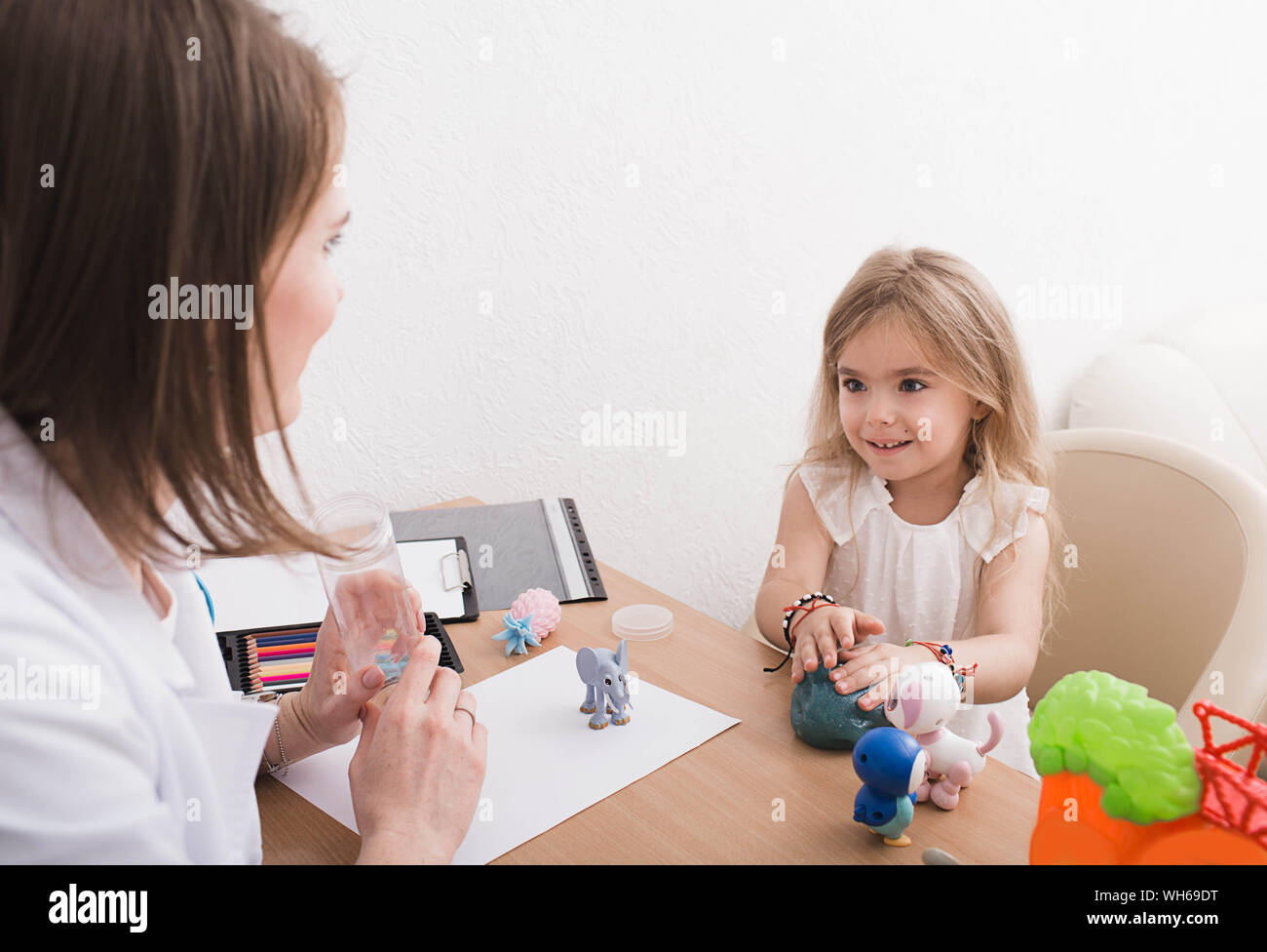 Süße kleine Mädchen tun, eine Übung in einer Therapiesitzung in der kinderpsychologe Büro Stockfoto