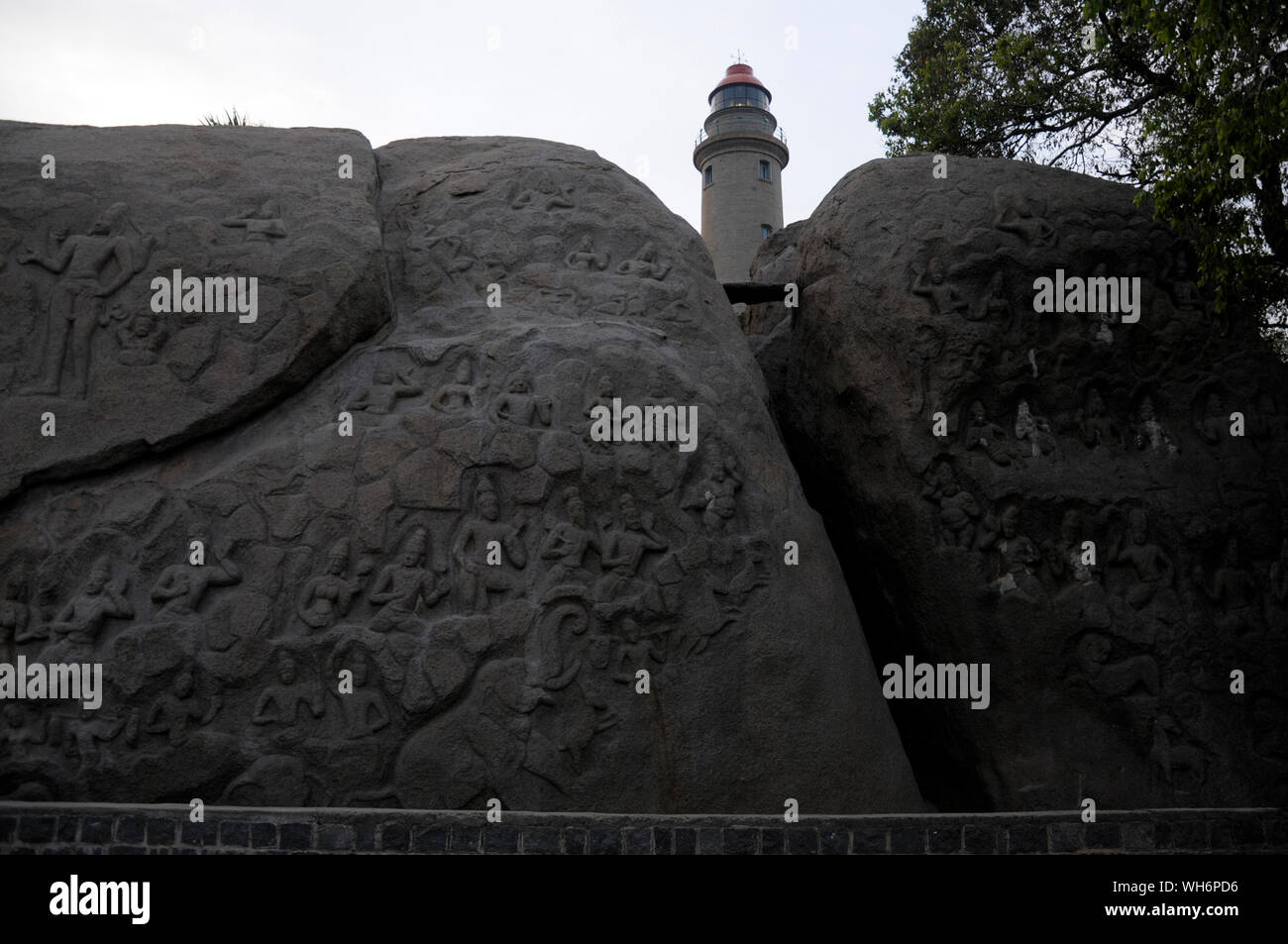 Ein Leuchtturm steht hinter einem Panel auf Rock Mahabalipuram in Tamil Nadu in Indien, die Geschichten aus der hinduistischen Mythologie. Foto: Sondeep Shanka Stockfoto