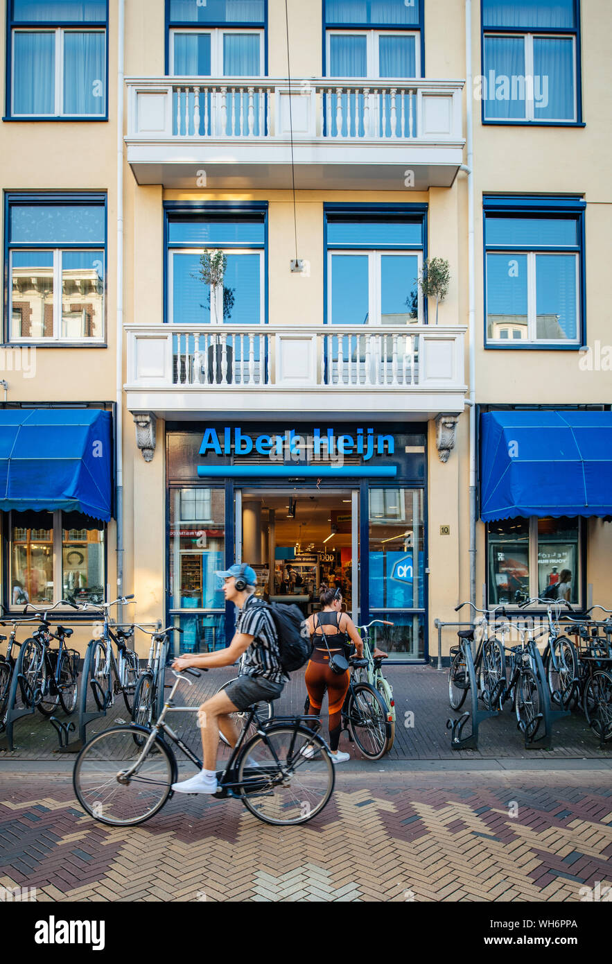 Haarlem, Niederlande - 26.August 2019: Ansicht der große Albert Heijn Supermarkt mit männlichen Radfahrer vor dem Gebäude Stockfoto