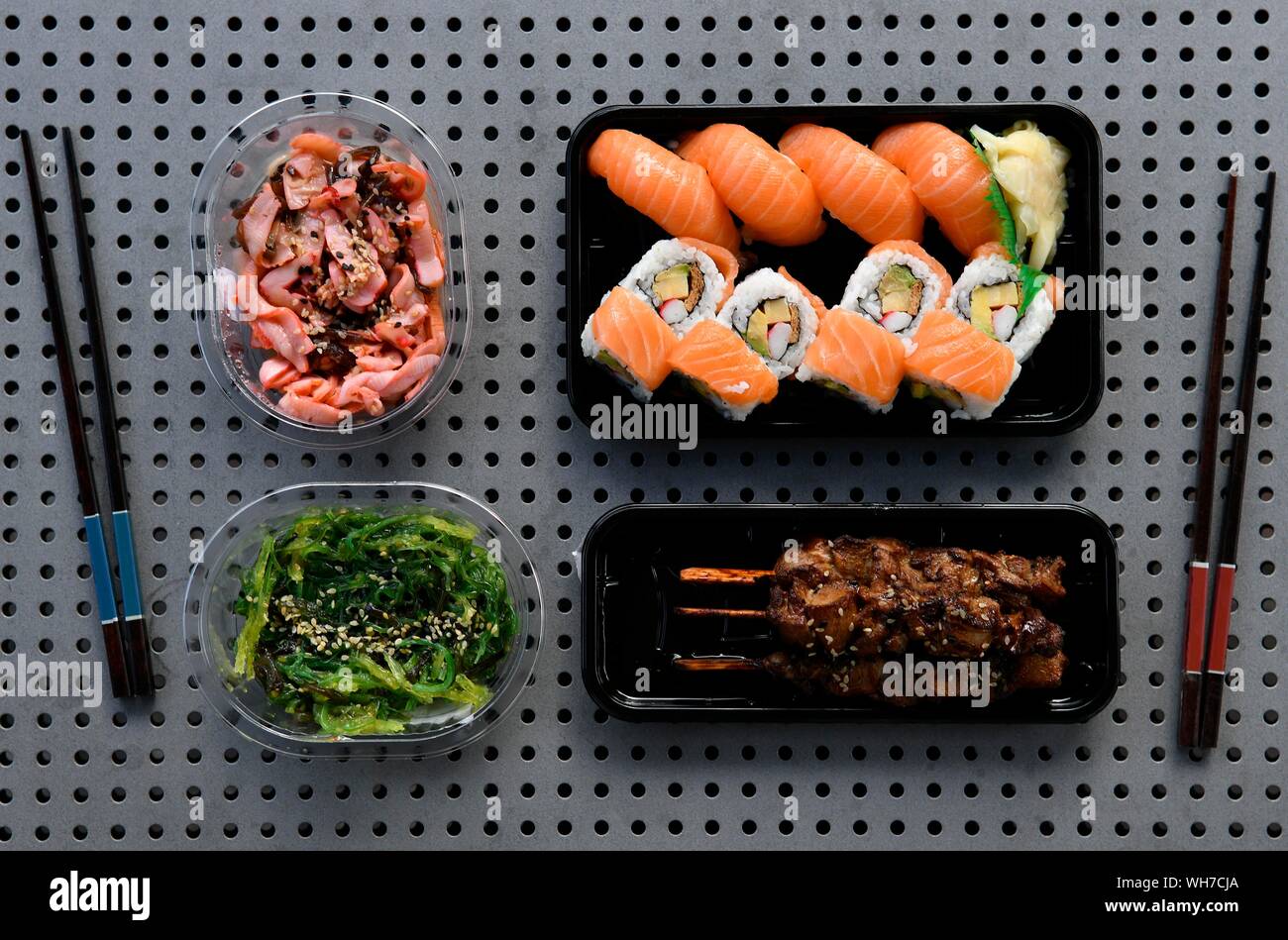 Mit UraMaki Sushi, Nigiri mit Lachs, Teriyaki Spieße, Goma Wakame Algen Salat, Chuka Ika Gummersbach, Oktopus Salat, Japanische Essstäbchen, in Kunststoff Stockfoto