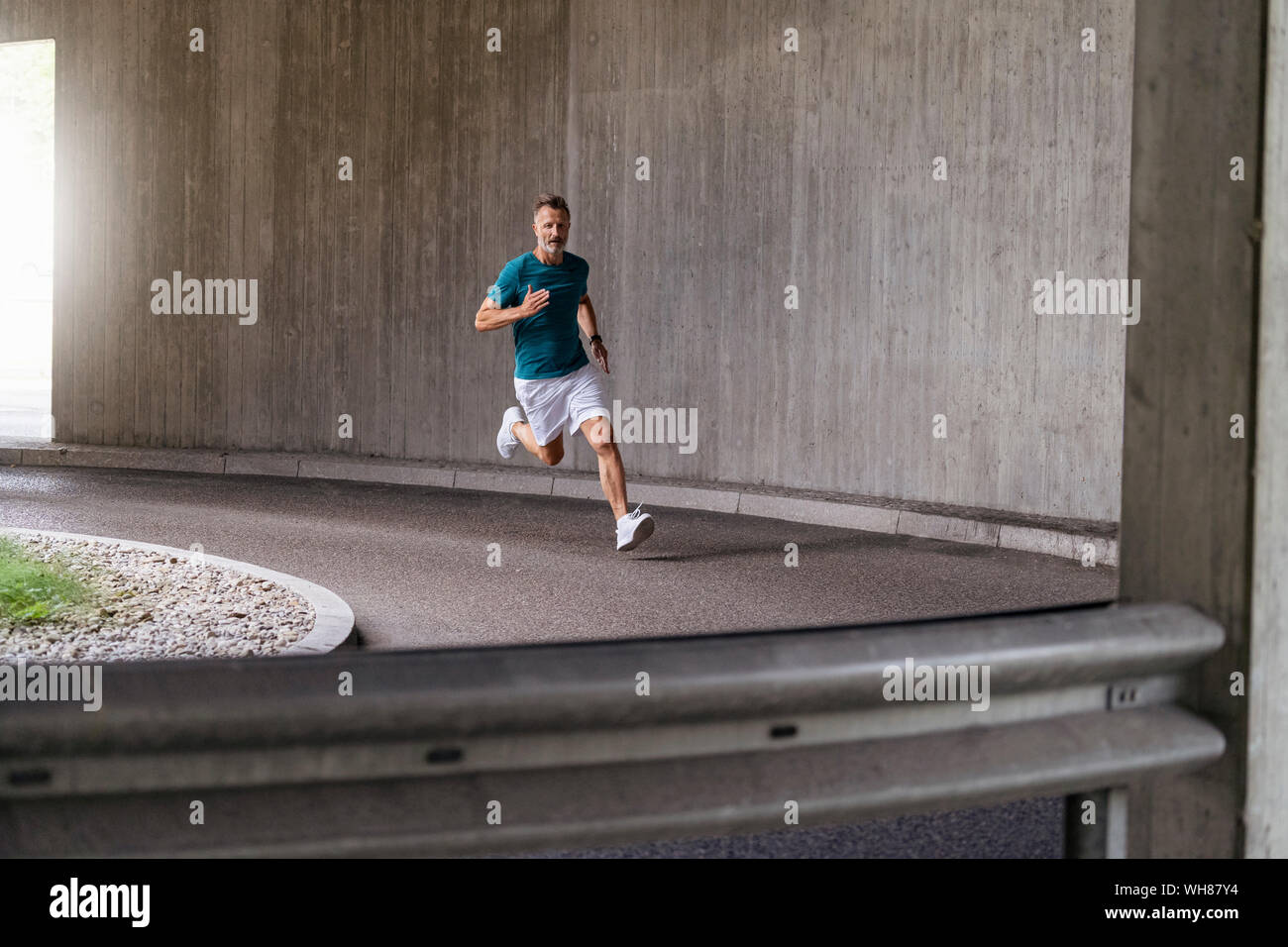 Sportliche Mann sprinten auf einer Straße Stockfoto