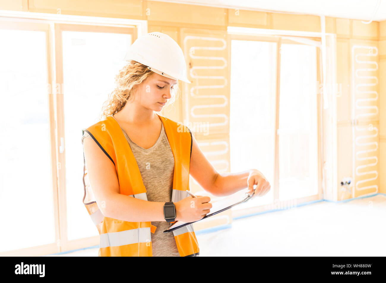 Junge Frau Kontrolle der Bau einer neuen Holzhaus Stockfoto