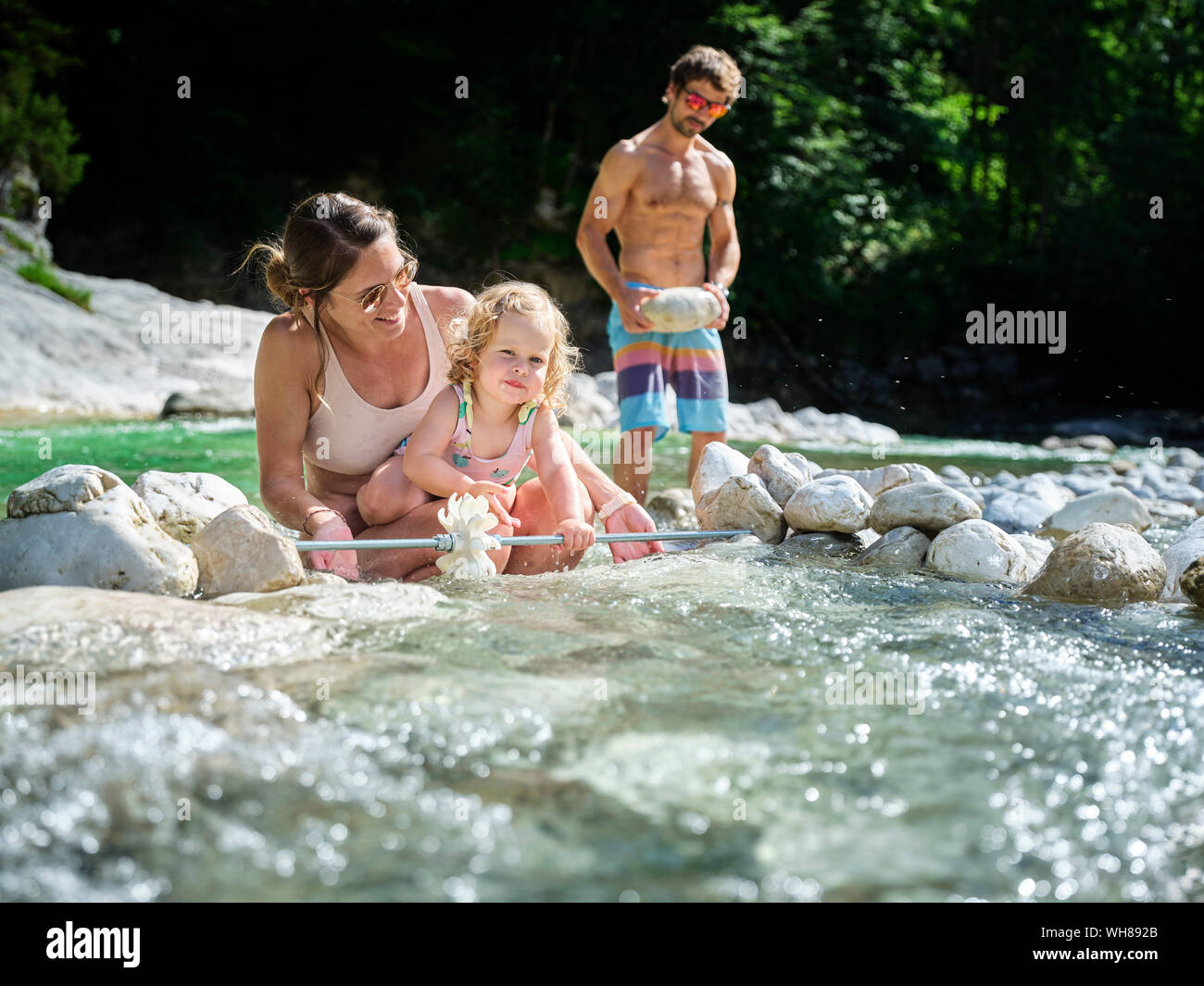 Familie mit Tochter zur Festsetzung Wasserrad in einem Bergbach Stockfoto