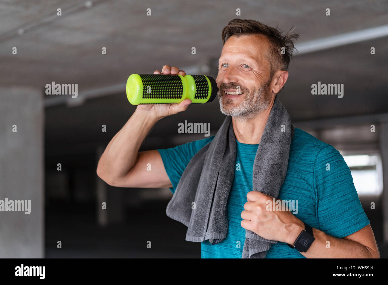 Sportlicher Mann mit Trinkflasche nach dem Workout Stockfoto