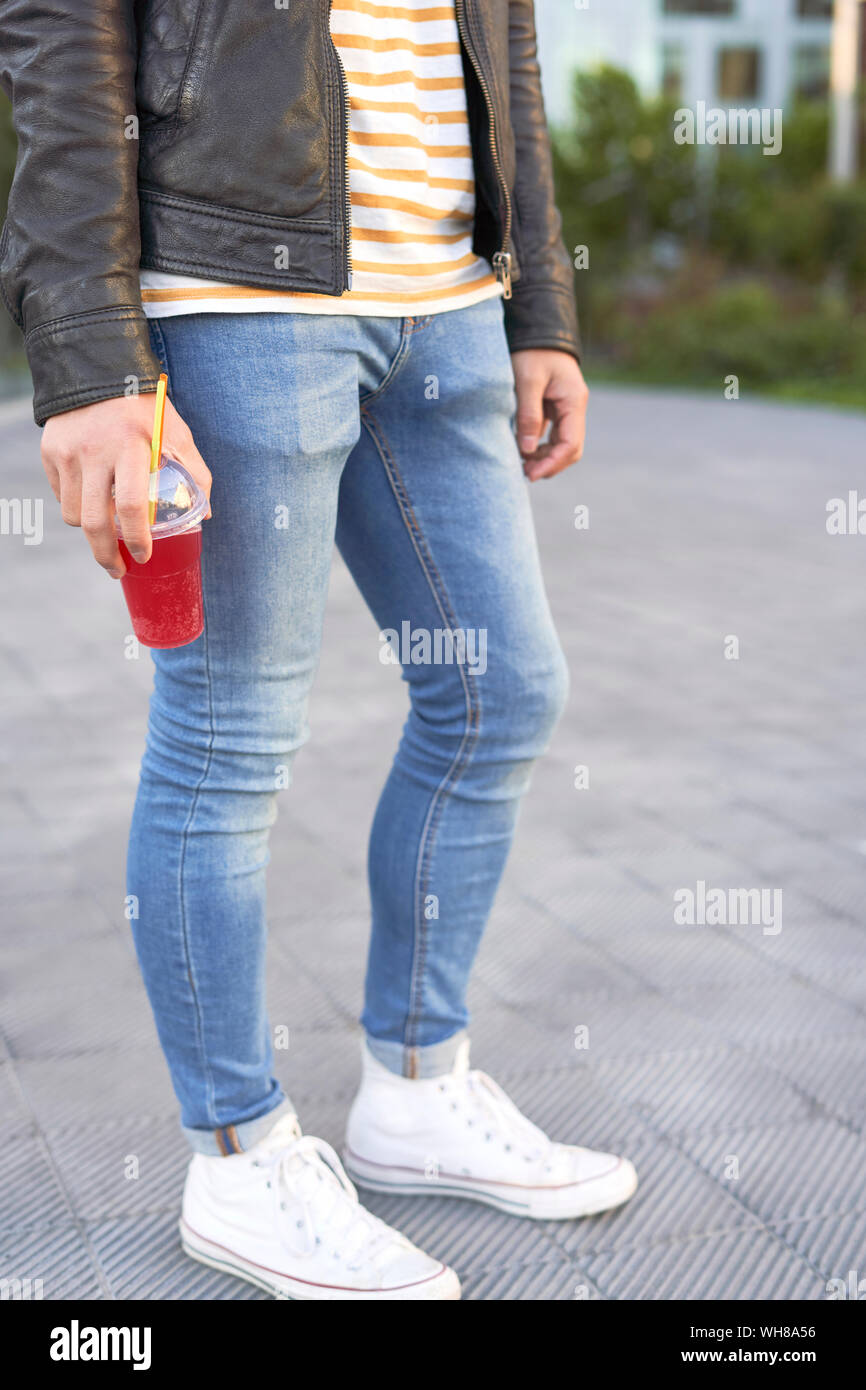 Mann stand auf der Fahrbahn halten Schale aus Kunststoff mit red Soft drink, Teilansicht Stockfoto