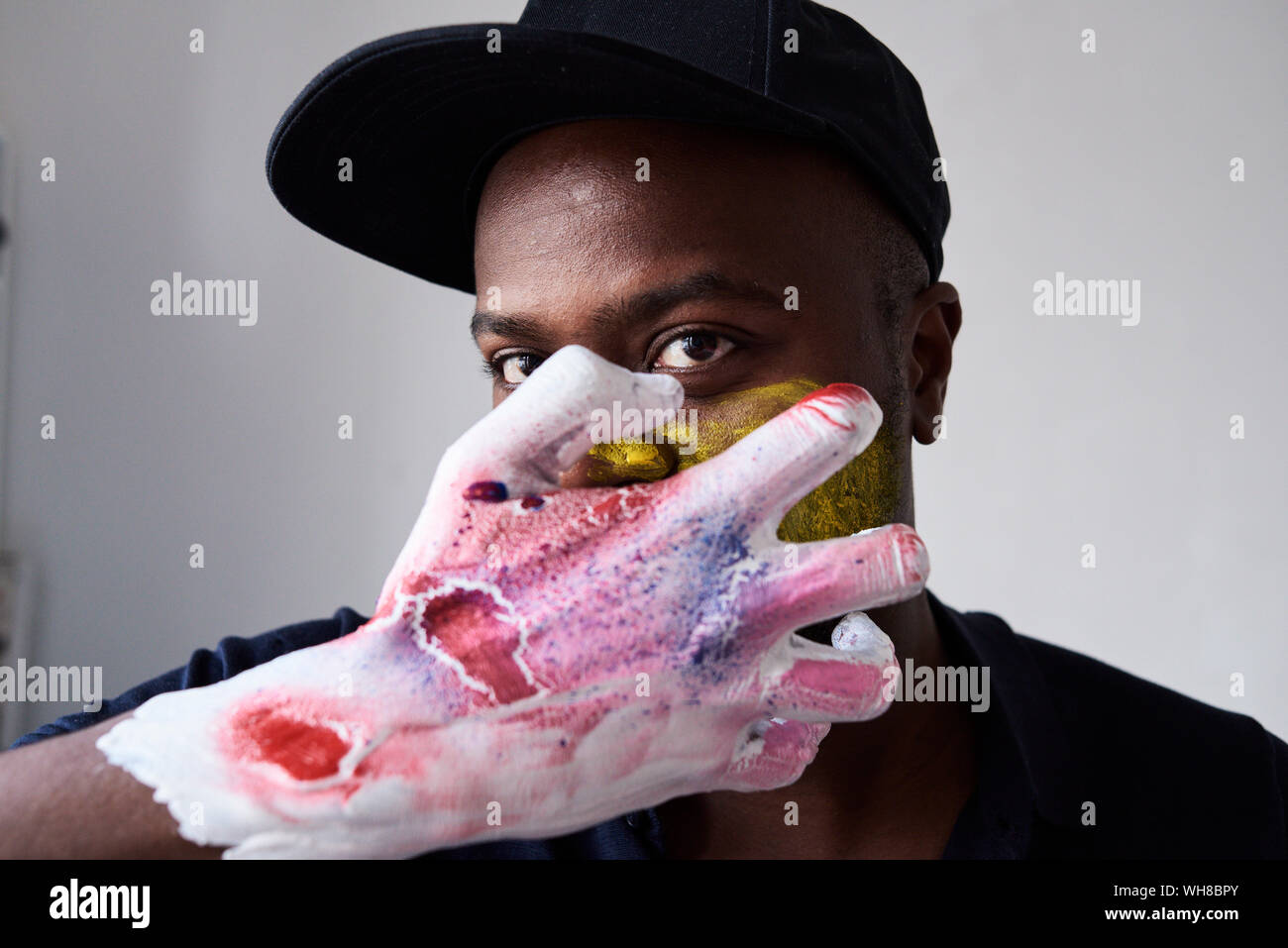 Wütend Künstler mit Hand in Farbe an Kamera schaut abgedeckt Stockfoto