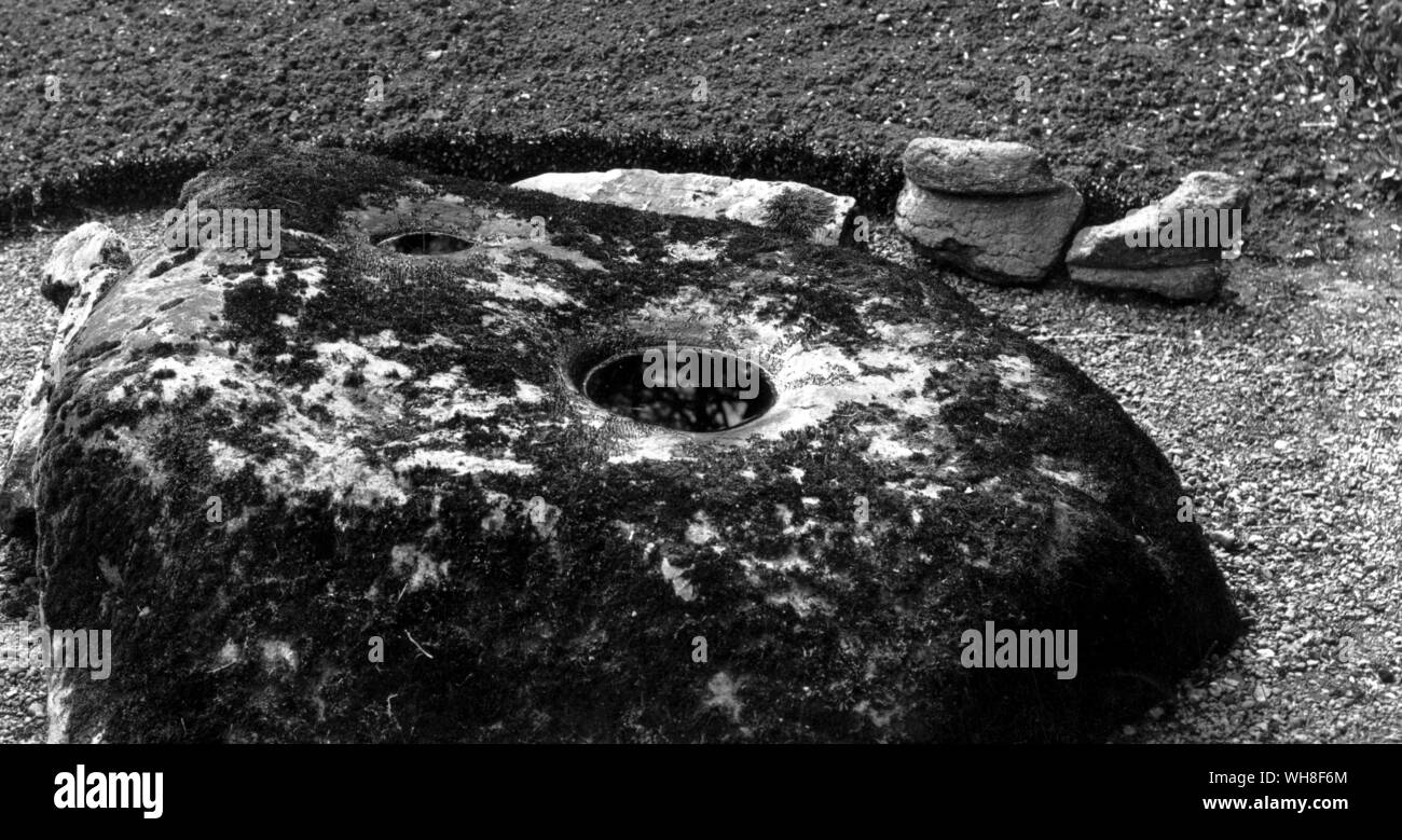 Bullaun Stein: Der Hexe Stein in der Nähe von Antrim, runden Turm. Stockfoto