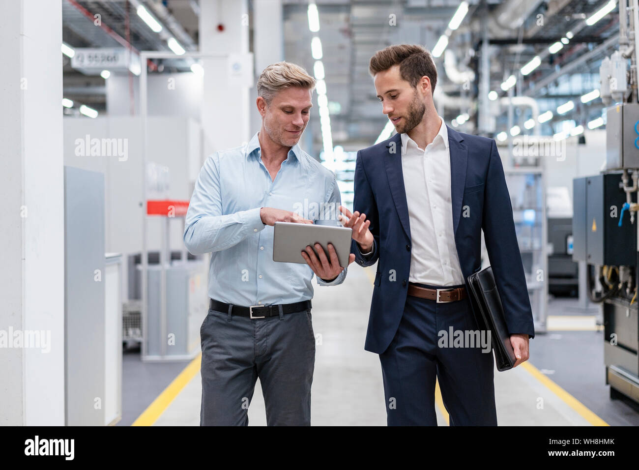 Zwei Geschäftsleute mit Tablet im Gespräch in ein modernes Werk Stockfoto
