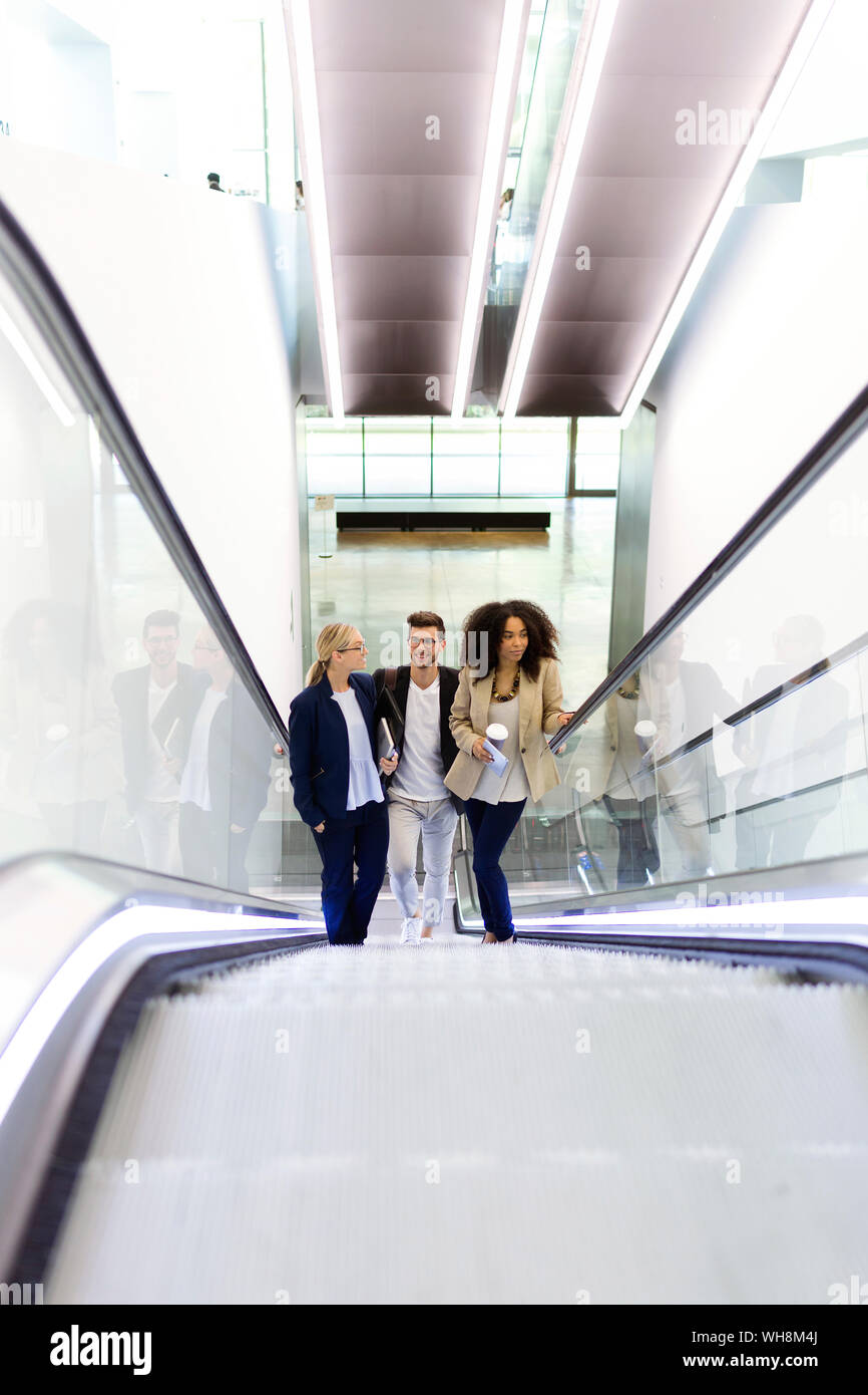 Junge Geschäftsleute auf einer Rolltreppe Stockfoto