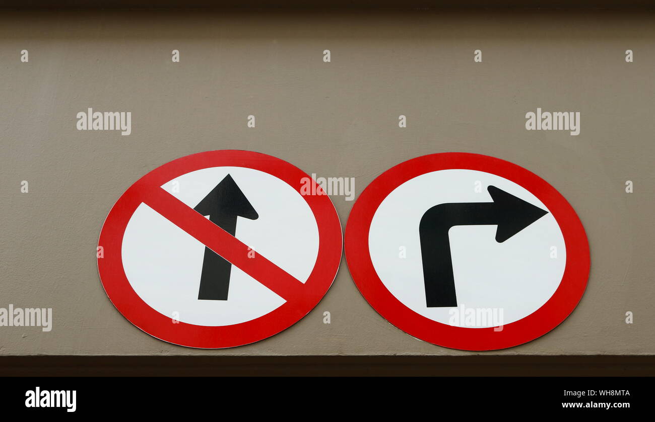 Zwei Verkehrszeichen kein Eintrag Closeup rechts und biegen Sie vor der Installation an der Wand eines Gebäudes, Low Angle View, keine Auswahl Konzept Stockfoto