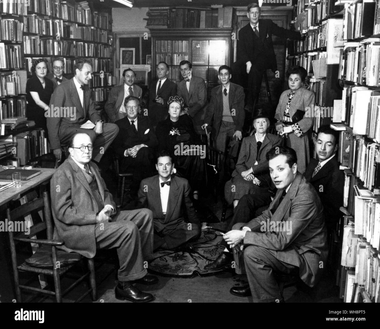Eine Aufnahme an der Gotham Book Mart für Edith und Osbert Sitwell, in der Mitte sitzt am 9. November 1948 Auden auf Leiter und rechts von ihm sitzt Elizabeth Bishop, Marianne Moore, Delmore Schwartz, Randall Jarrell, Charles Henri Ford, William Rose Benet, Stephen Spender, Marya Zaturenska, Horace Gregory, Tennessee Williams, Richard Eberhart, Gore Vidal und Jose Garcia Villa Stockfoto