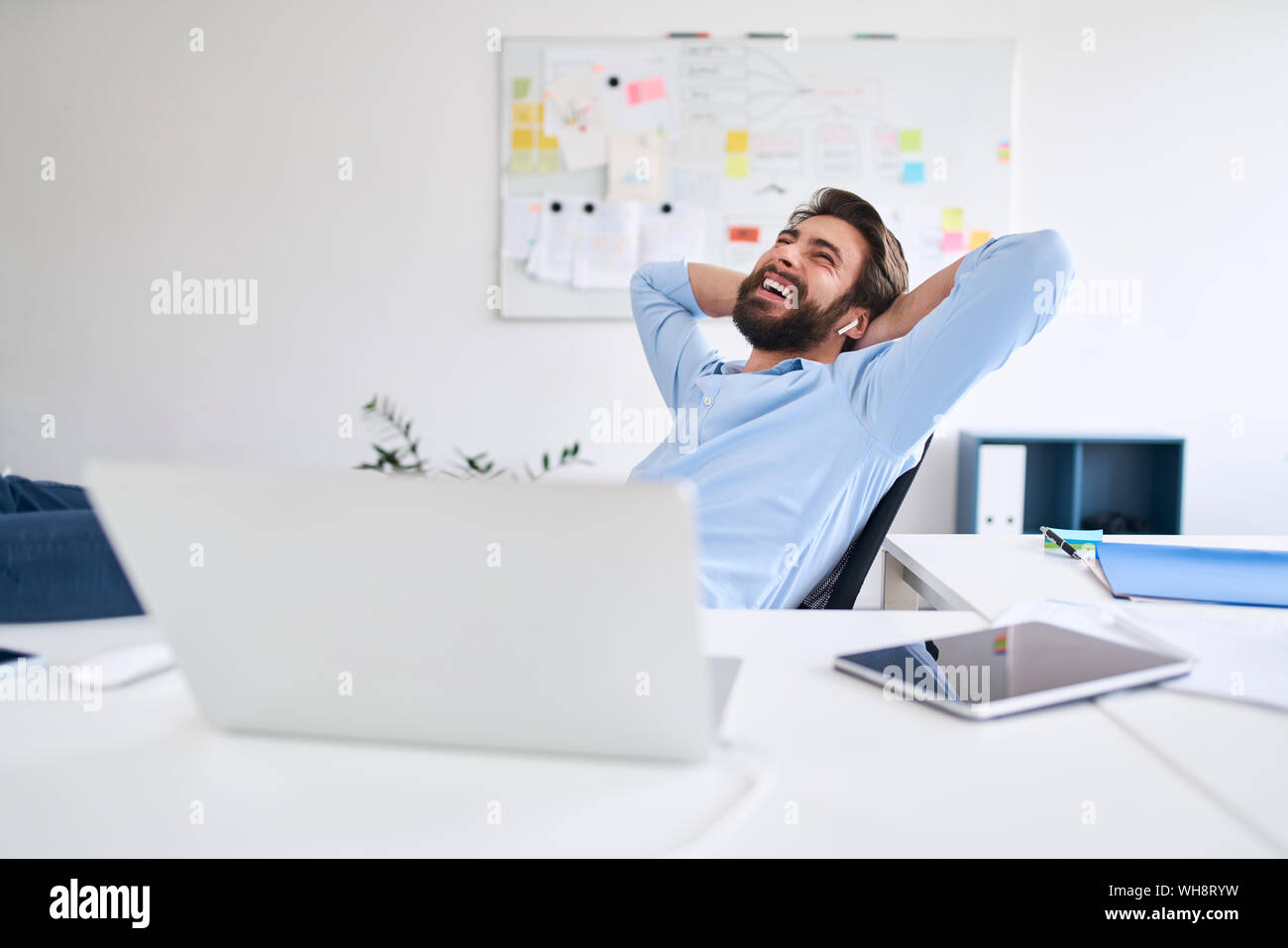 Lachend Geschäftsmann an einem Schreibtisch sitzen Stockfoto