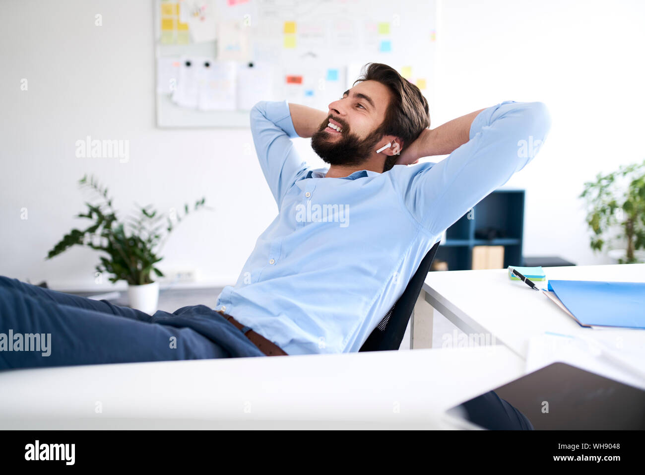 Lächelnd Geschäftsmann an einem Schreibtisch sitzen Stockfoto