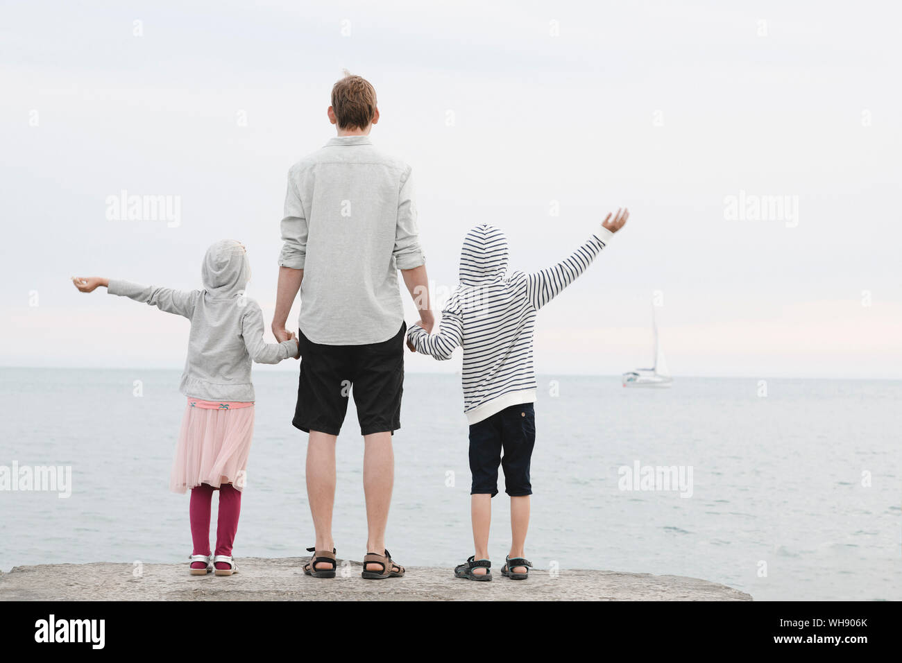 Rückansicht der Mann, der vor dem Meer mit kleinen Tochter und Sohn im Abstand suchen Stockfoto