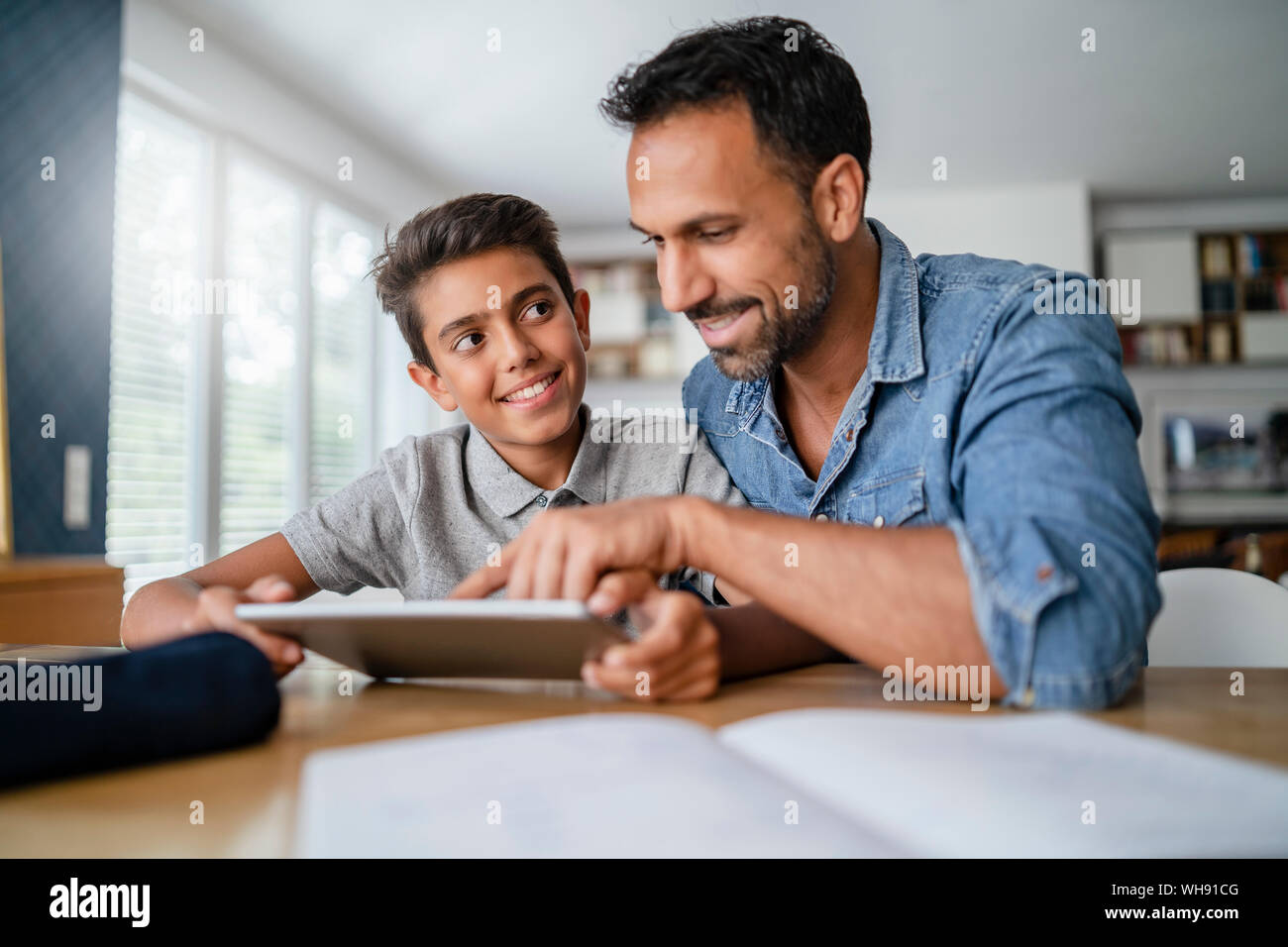 Vater und mit Tablet und Hausaufgaben Sohn Stockfoto