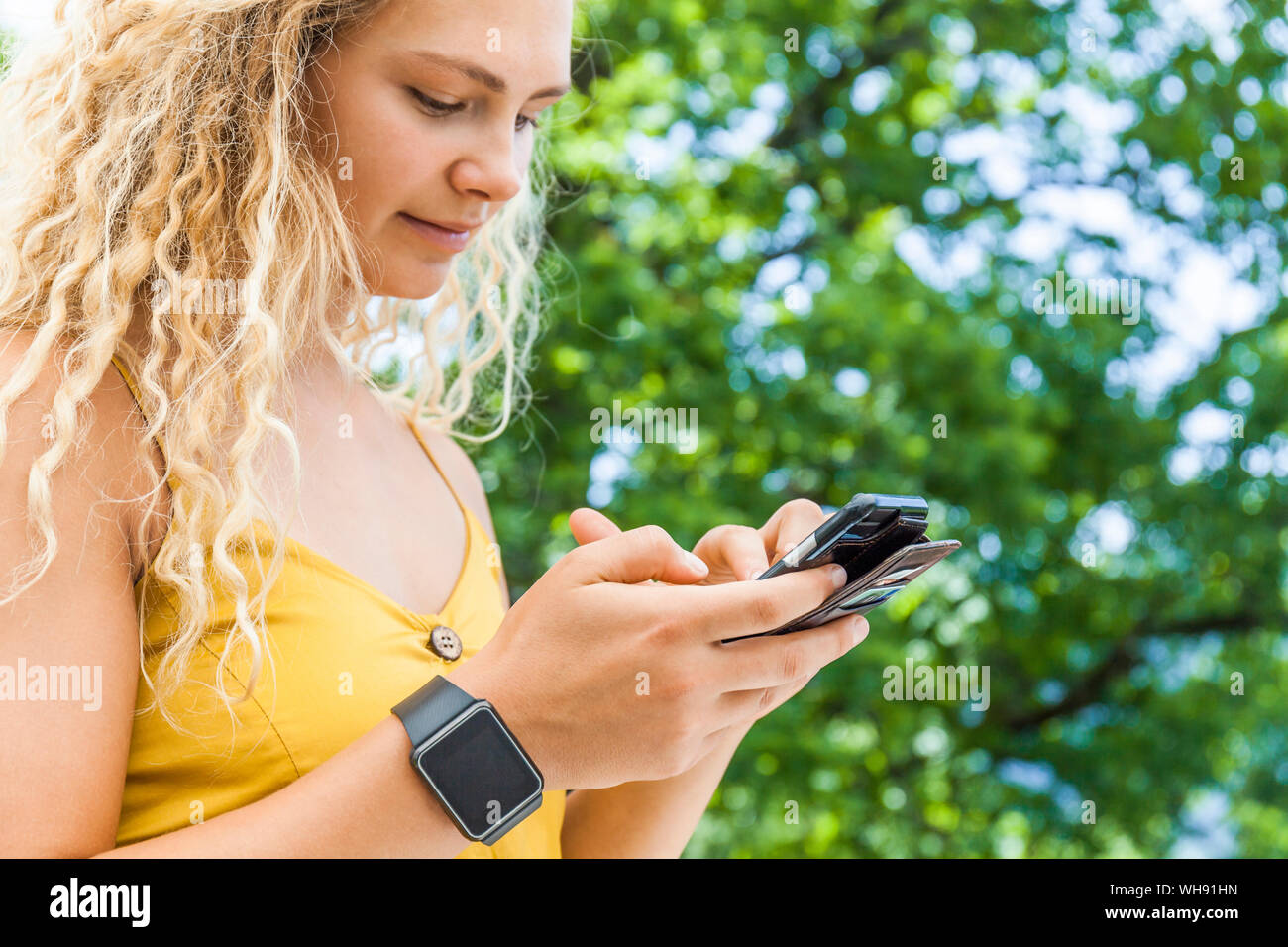 Frau mit Smartphone, Digitaluhr Stockfoto