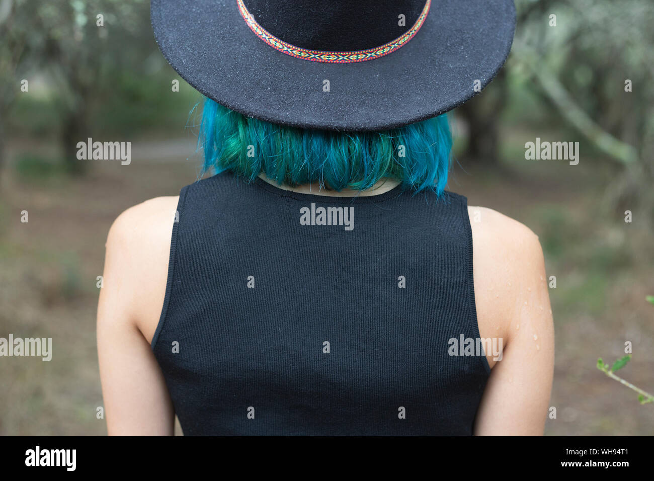 Zurück Blick auf junge Frau mit blau und grün gefärbte Haare mit schwarzen Hut Stockfoto