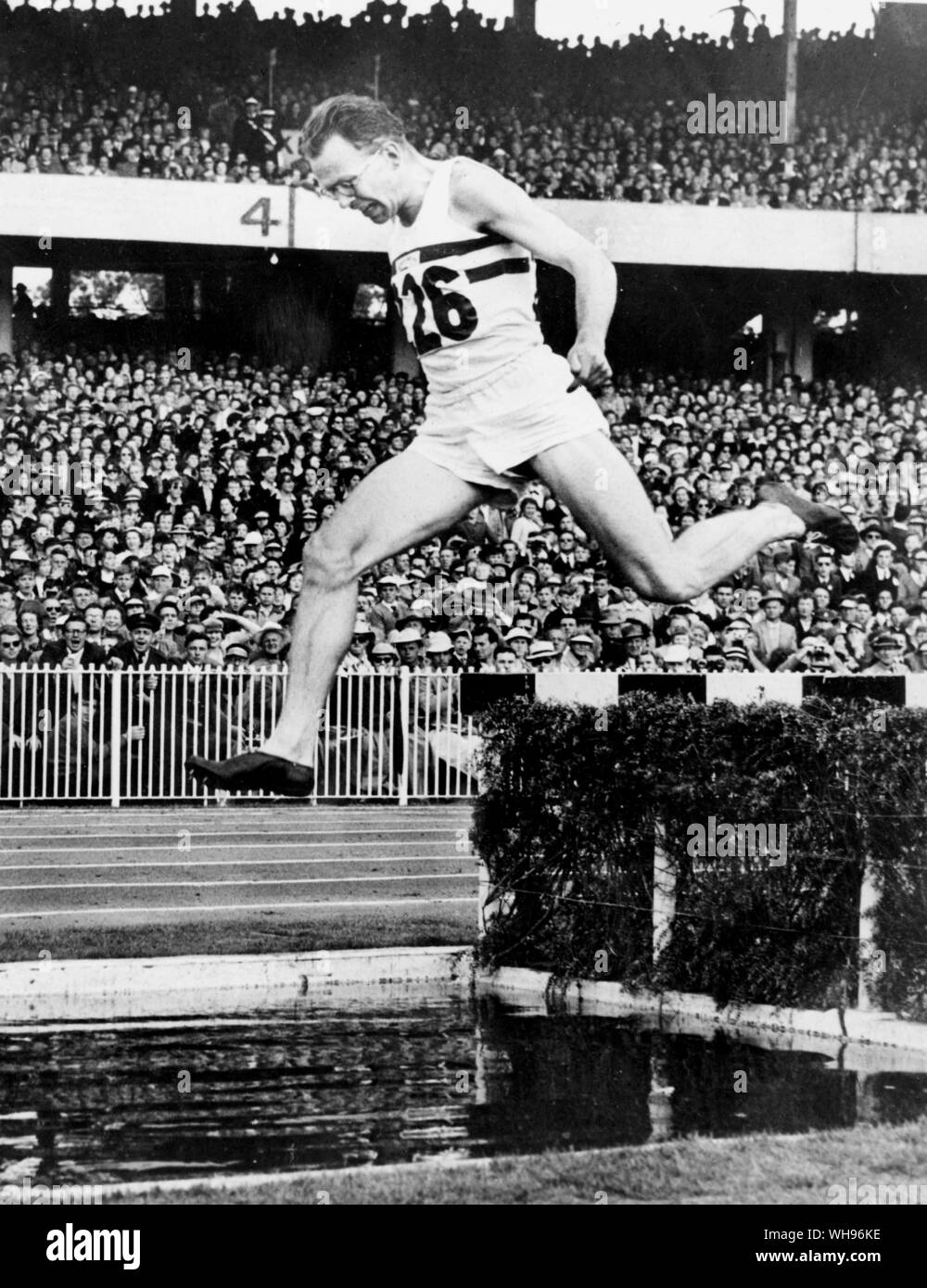 Aus., Melbourne, Olympics, 1956: Chris Brasher von Großbritannien am Wasser Sprung auf die letzte Runde der 3000m Hindernislauf.. Stockfoto