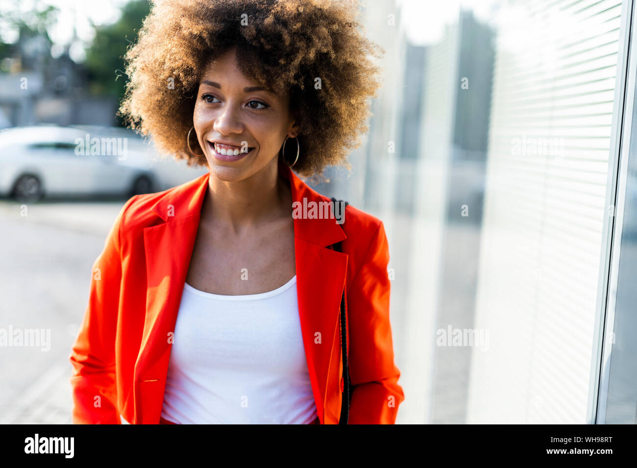 Portrait von lächelnden jungen Frau das Tragen modischer roten Anzug Jacke Stockfoto
