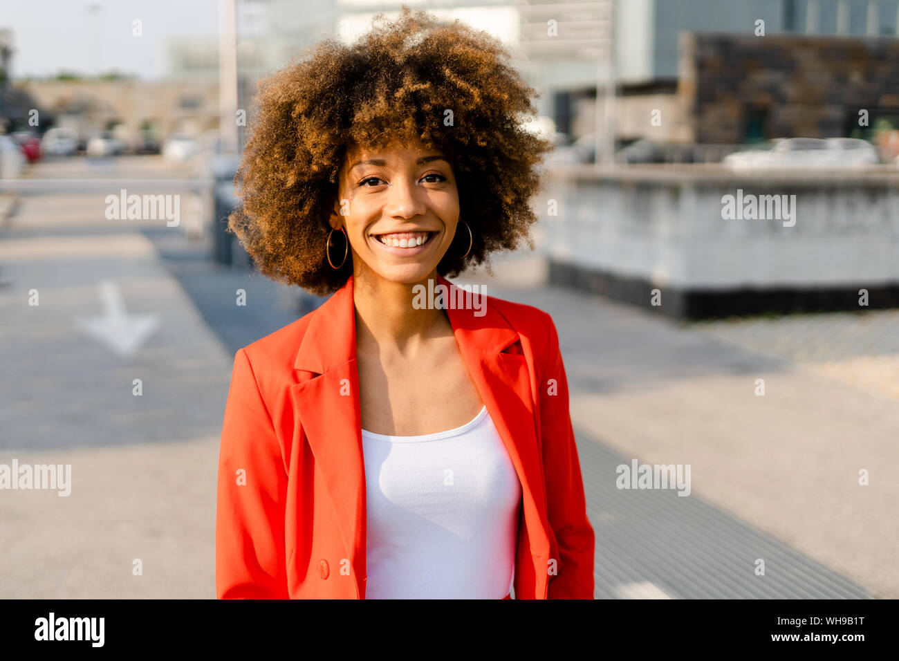 Portrait von lächelnden jungen Frau das Tragen der roten Anzug Mantel Stockfoto