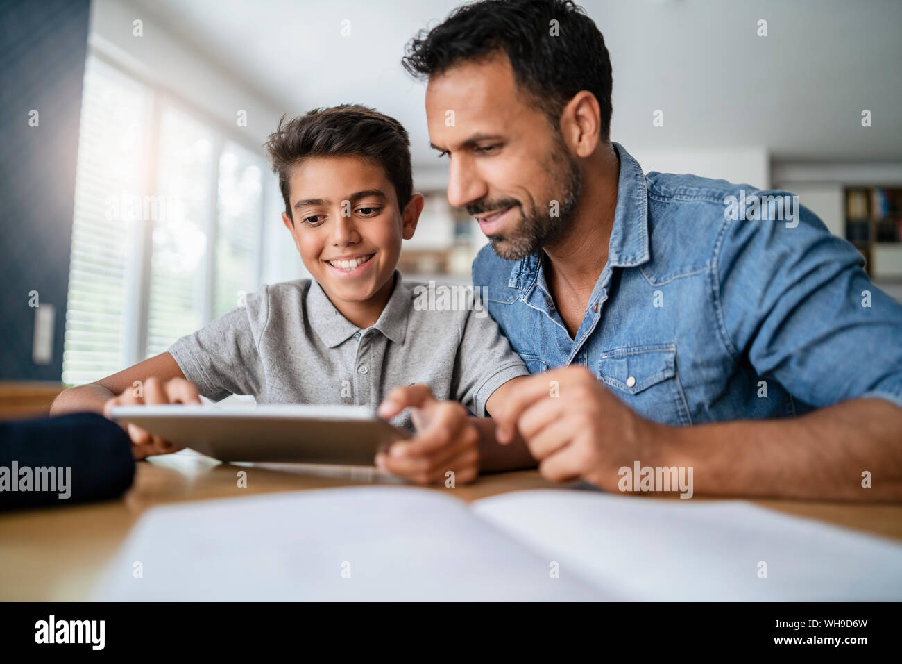 Vater und mit Tablet und Hausaufgaben Sohn Stockfoto