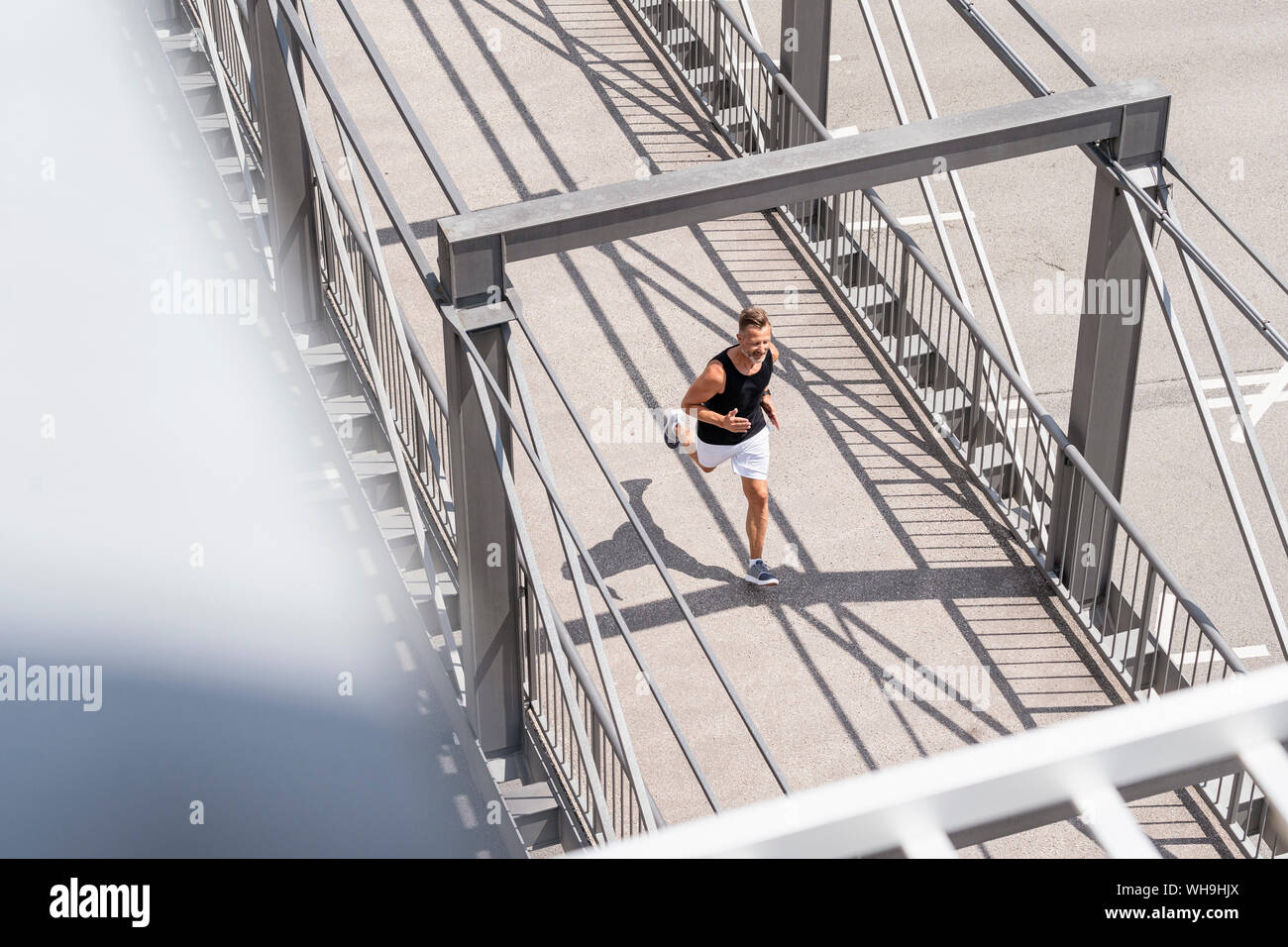 Sportliche Menschen joggen über die Brücke Stockfoto