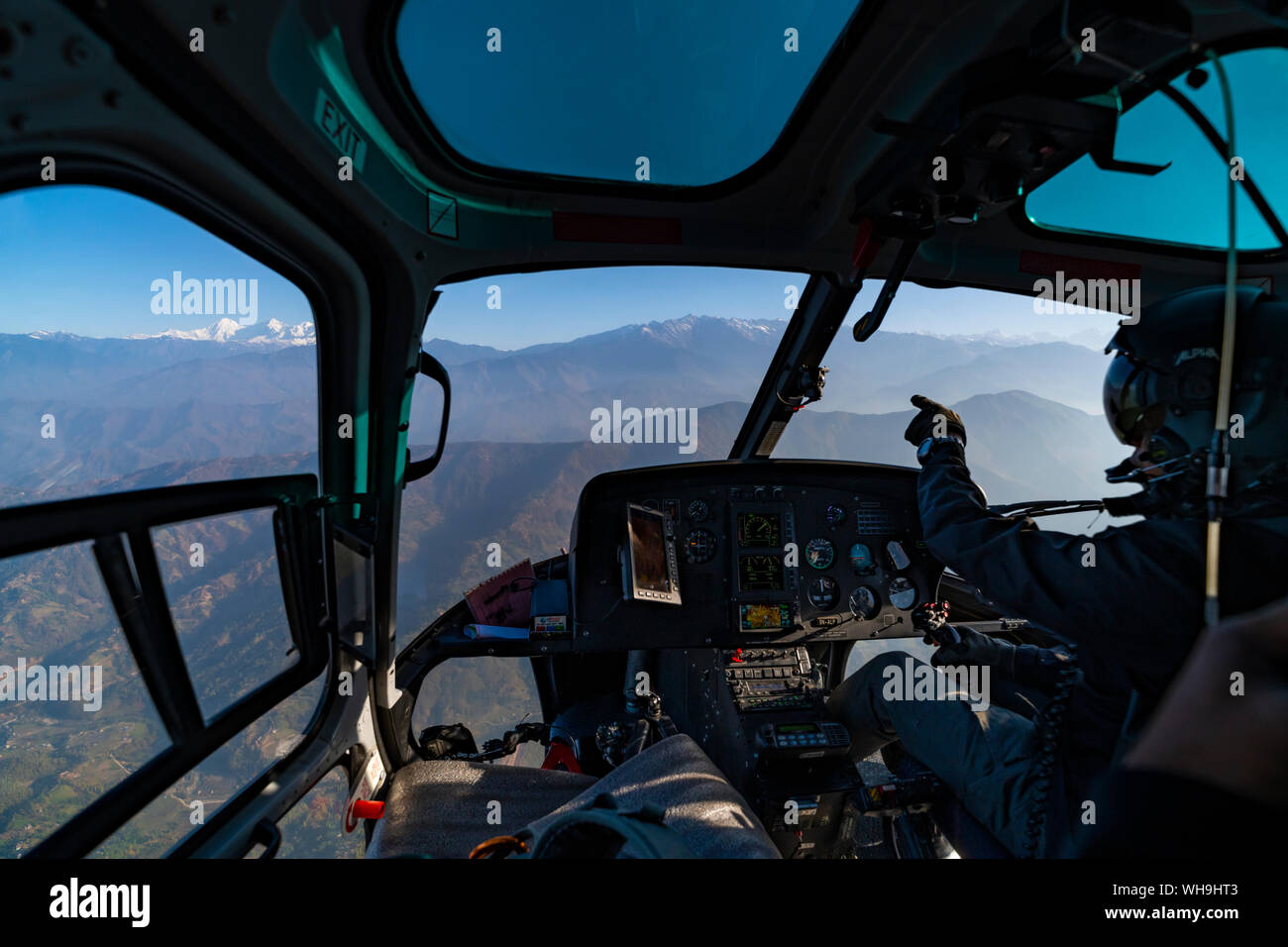 Ein Helikopter fliegt in Richtung des Himalaya, wie der Pilot in Richtung des Ganesh Himal Bereich durch das Fenster, Langtang region, Nepal, Asien Stockfoto