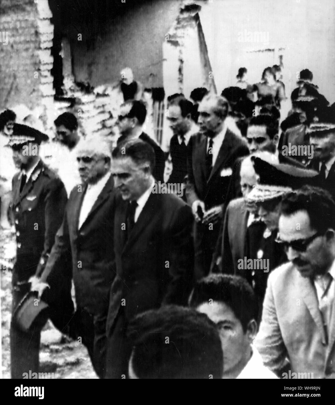 Lima, Perus, 19. Oktober 1966: Präsident Fernando Belaunde (Mitte, dunkle Haare), Besuche die Ruinen der Stadt Godoy, 120 km nördlich von Lima. Von den lokalen und nationalen Beamten begleitet, der Präsident tourte die Gebiete Perus, die stark von einem Erdbeben beschädigt wurden. Stockfoto