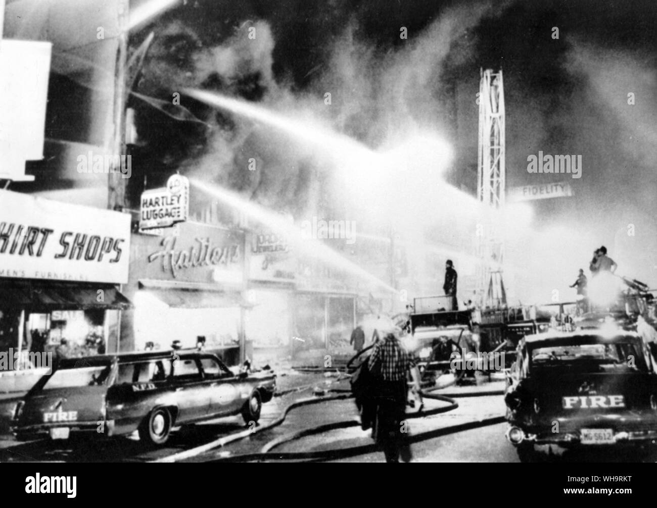 14. Juli 1967: Newark, New Jersey, USA: Feuerwehrleute kämpfen in einem Geschäft in der Innenstadt von Newark gegen einen Brand. In der zweiten Nacht der Unruhen in der Stadt. Stockfoto