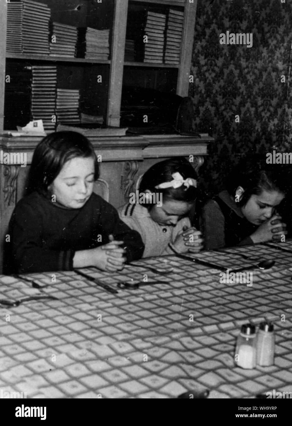 WW2: Britische Kinder. Umsiedler im Gebet um Tisch. Stockfoto