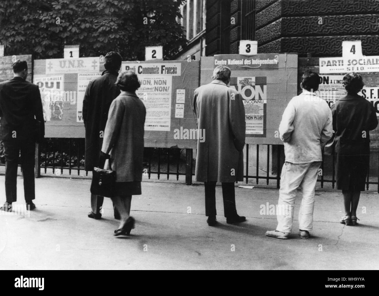 25. Oktober 1962: Referedum hustings in Frankreich. Die Passanten auf der Straße lesen Sie die Argumente auf Paris Poster. Ja, sagt die UNR Poster auf der linken Seite; Nein, nein, nein, sagen die anderen drei. Da das Referendum über die Verfassung Präsident De Gaulle Vorschläge nähert, Party Poster werden in ganz Frankreich. Stockfoto
