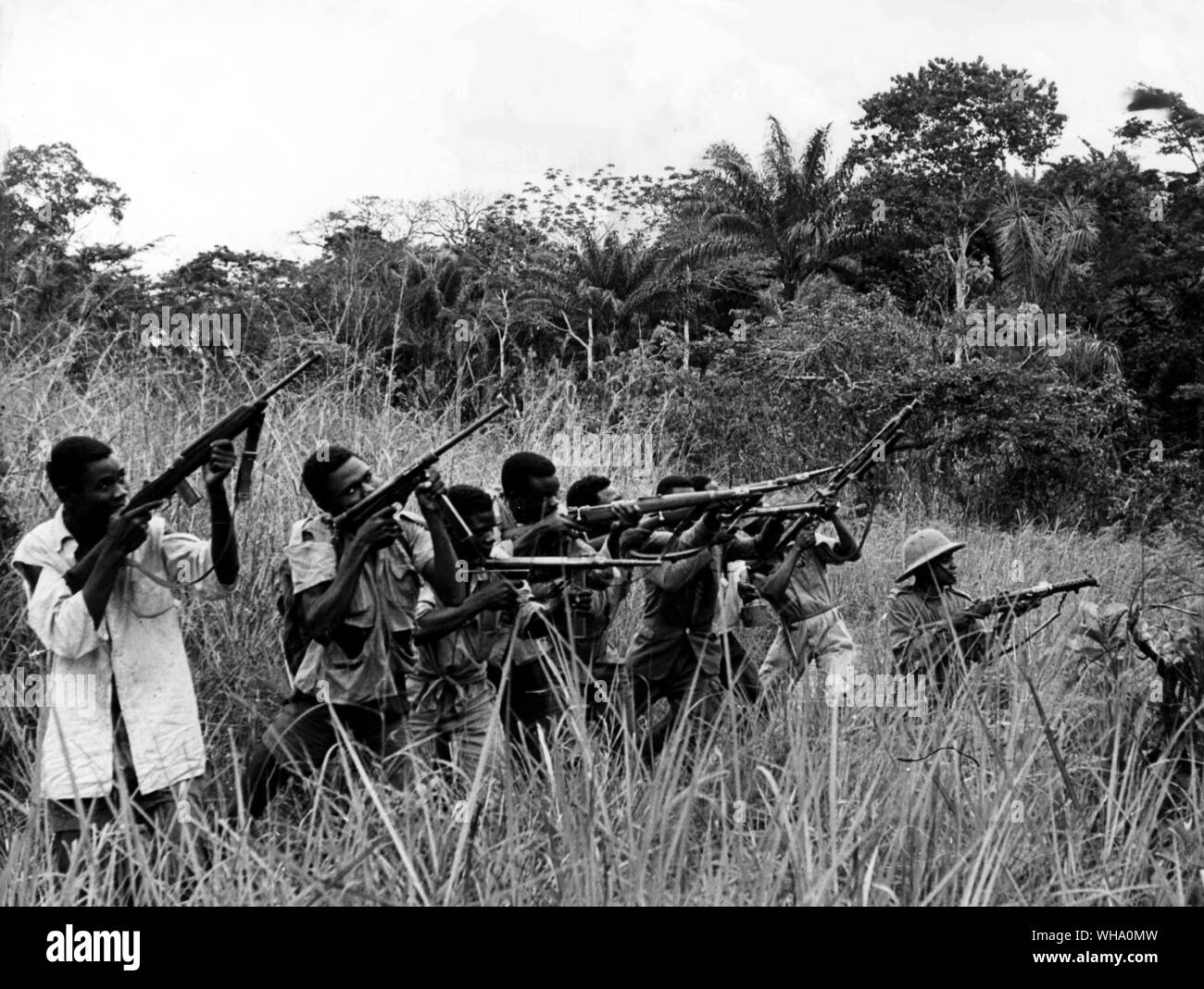 Angola Rebellen zu kämpfen. Die Hälfte im hohen Elefantengras versteckt, eine Patrouille stolz zeigen, wie effizient sie ihre Waffen umgehen kann. Stockfoto
